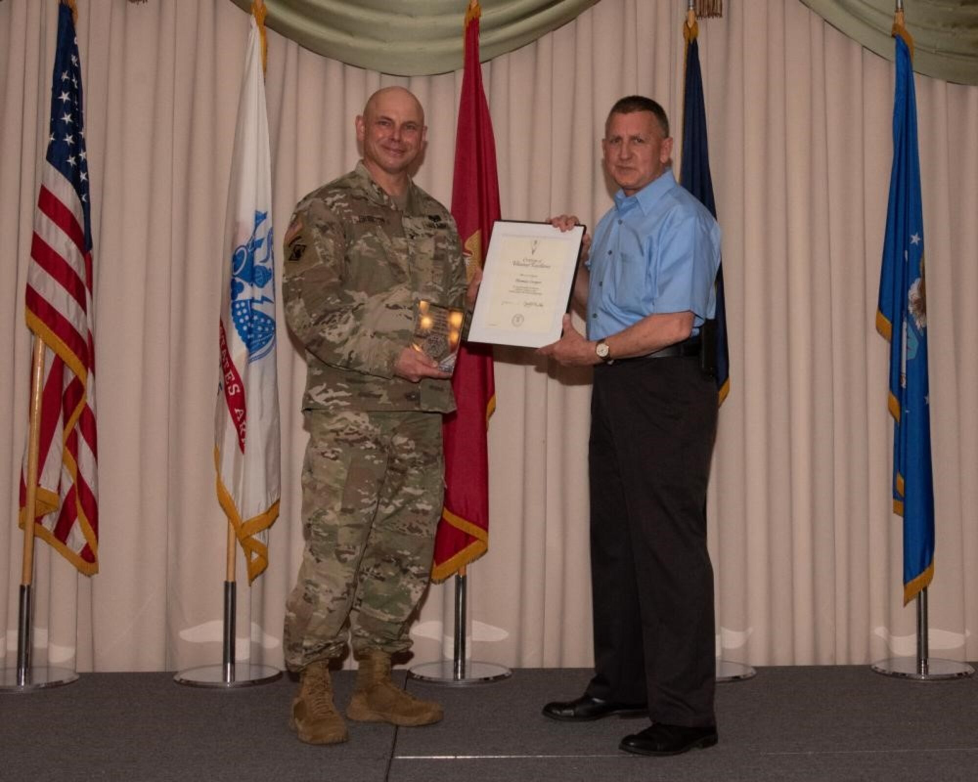 U.S. Army Col. Jon Brierton, Army Support Activitiy, Fort Dix Commander and Joint Base McGuire-Dix-Lakehurst, N.J., Deputy Commander, presents award to Thomas Cooper April 14, 2022 at Tommy B's Community Activities Center. Cooper was recognized for the volunteer excellence award.