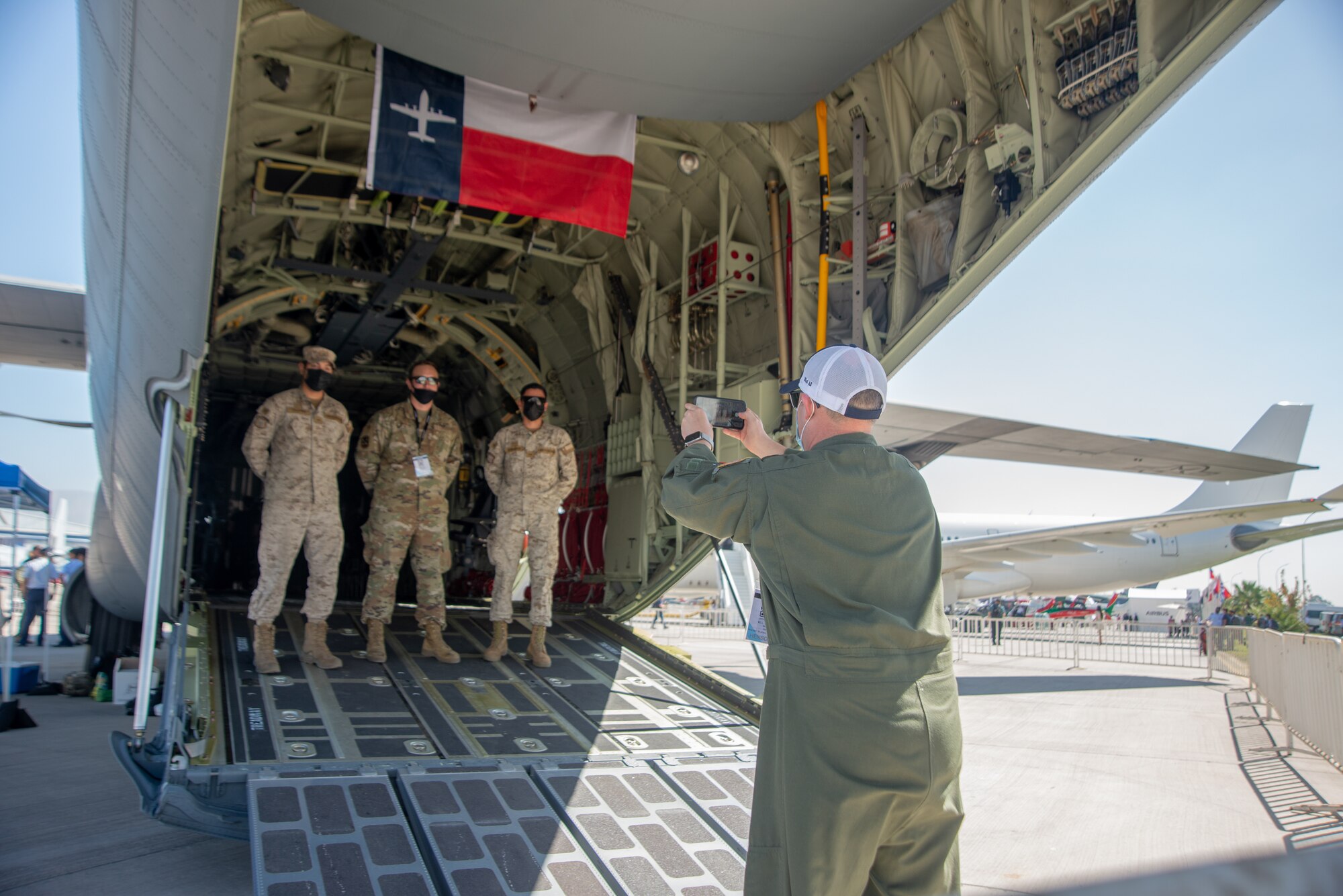 Airman photographs Airmen inside a C-130J.