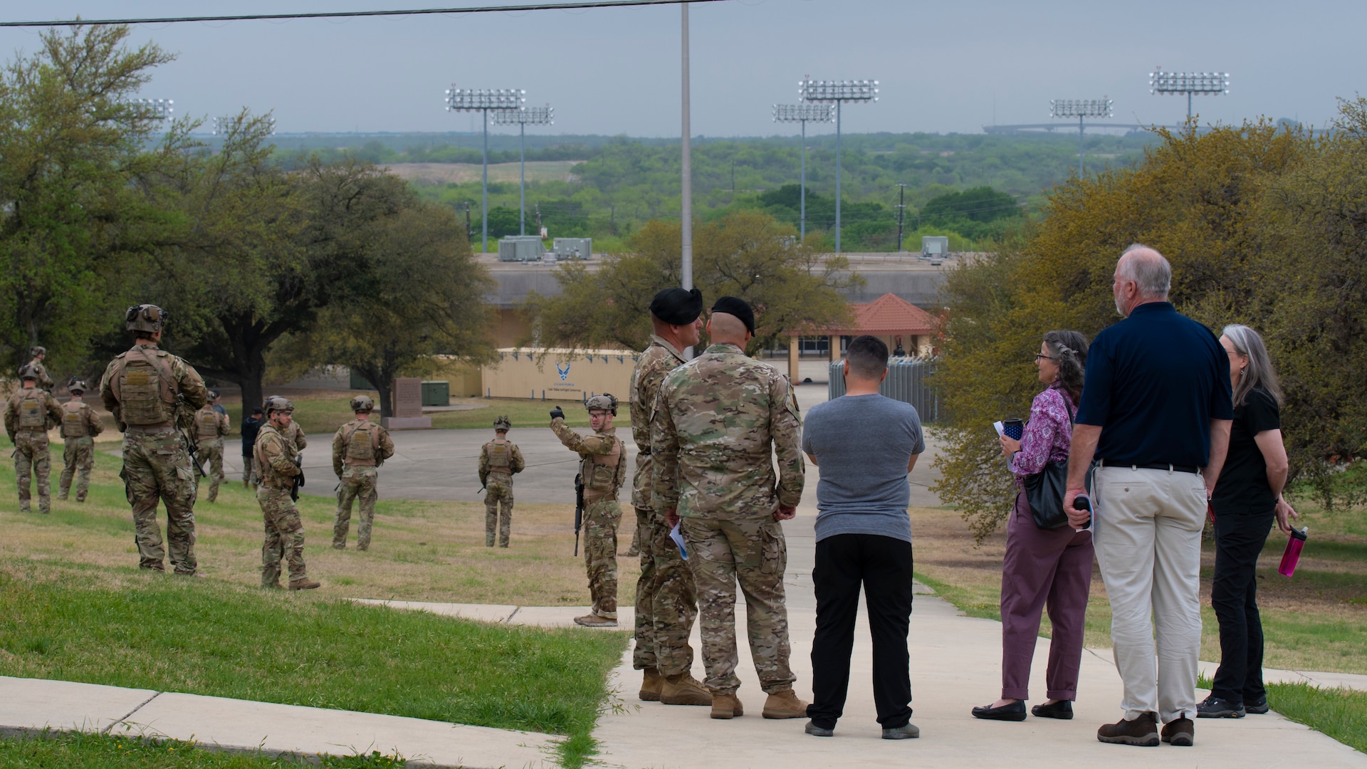 Dr. Wendy Walsh (third from right), Air Education and Training Command chief learning officer and Dr. Brian Davis (second from right), Second Air Force chief training officer, observe Tactical Air Control Party candidates in the 353rd Special Warfare Training Squadron practice small unit tactics with Dr. Karal Garcia (far right), Special Warfare Training Group training adisor,  Chief Master Sgt. Jason Hammel (sixth from right), 353rd SWTS senior enlisted leader, and Maj. William West (fifth from right), 353rd SWTS director of operations at Joint Base San Antonio-Chapman Training Annex, Texas, Apr. 4, 2022. Walsh and her team participated in an immersion tour of the SWTW to learn about how the SWTW builds Air Force Special Warfare Airmen and prepares them for combat.