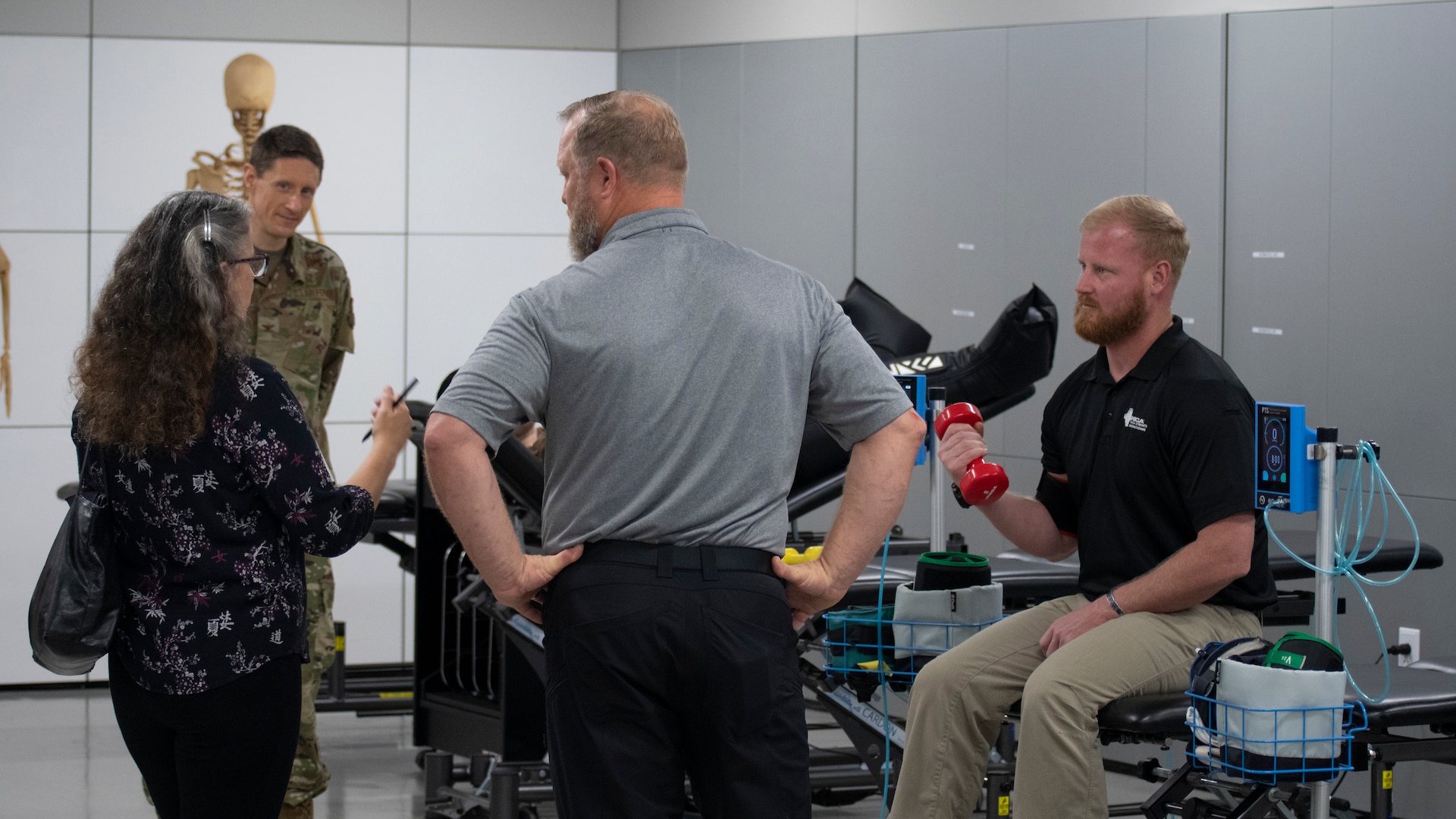 Dr. Wendy Walsh (left), Air Education and Training Command chief learning officer, observes Mr. Tyler Christiansen (right), Special Warfare Human Performance Support Group human performance director, conduct a blood flow restriction exercise with Dr. Joseph Kirkman (center), Special Warfare Operational Medicine Squadron supervisory physical therapist, at the Special Warfare Training Wing Human Performance Training Center on Joint Base San Antonio-Chapman Training Annex, Texas, April 5, 2022. Dr. Walsh and her team participated in an immersion tour of the SWTW to learn about how the SWTW builds Air Force Special Warfare Airmen and prepares them for combat.