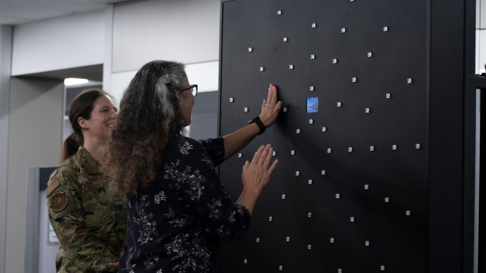 Dr. Wendy Walsh (center), Air Education and Training Command chief learning officer, executes a reaction time training exercise as Maj. Jessica Carpenter (left), Special Warfare Human Performance Squadron conditioning flight commander, watches at the Special Warfare Training Wing Human Performance Training Center on Joint Base San Antonio-Chapman Training Annex, Texas, April 5, 2022. Walsh and her team participated in an immersion tour of the SWTW to learn about how the SWTW builds Air Force Special Warfare Airmen and prepares them for combat.