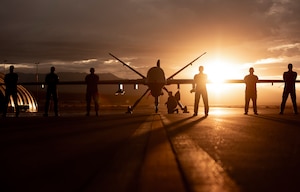432nd Wing/432nd Air Expeditionary Wing Airmen pose with an MQ-9 Reaper for a photo at Creech Air Force Base, Nev., Nov. 19, 2019. The MQ-9 and its aircrew are one of the most demanded U.S. Air Force assets due to its ability to be employed primarily against dynamic targets and secondarily as an intelligence collection asset. (U.S. Air Force photo by Airman 1st Class William Rio Rosado)