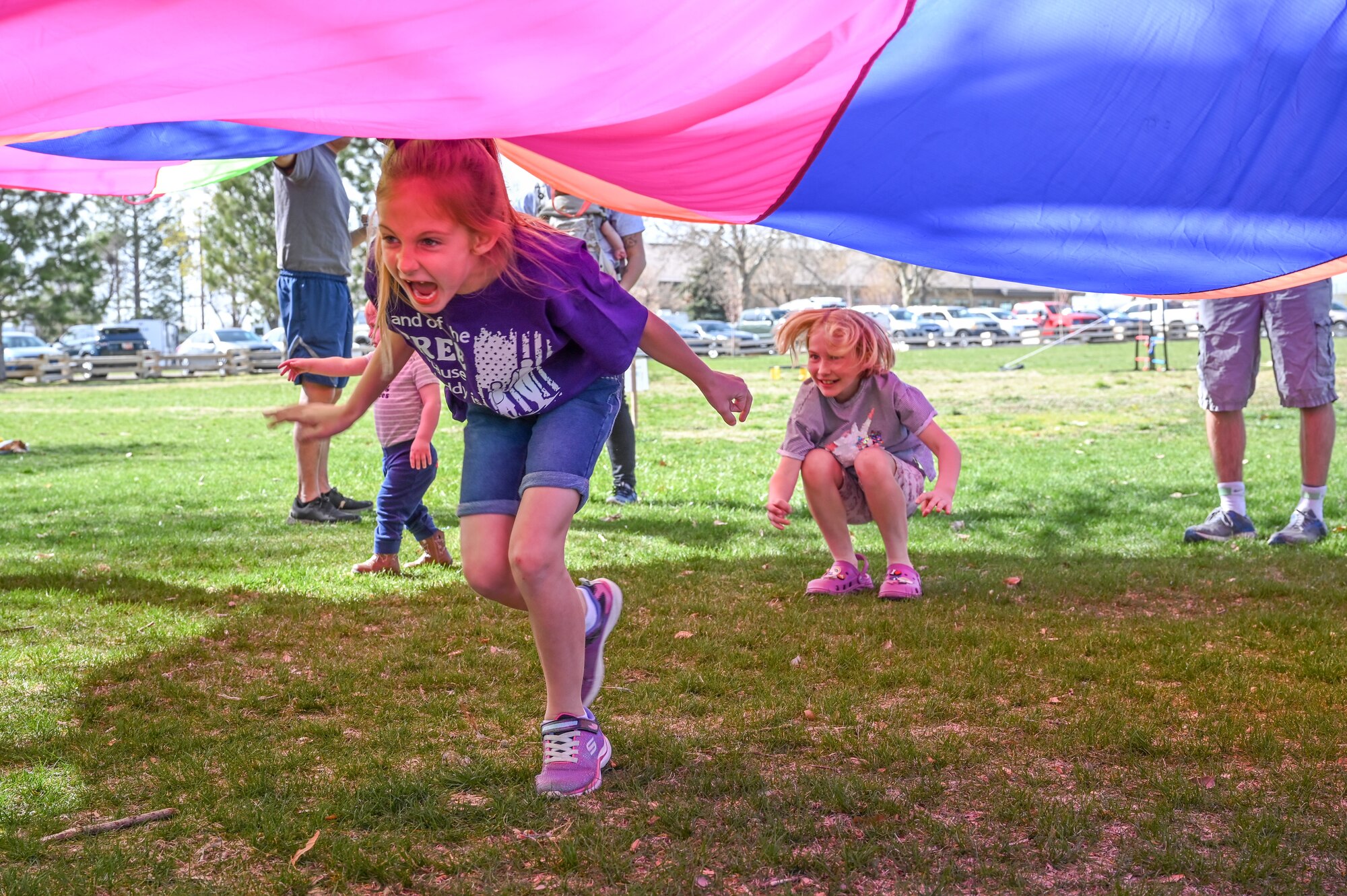 Children run under a parachute during the “Show Up for Military Families” field day April 19, 2022, at Hill Air Force Base, Utah.