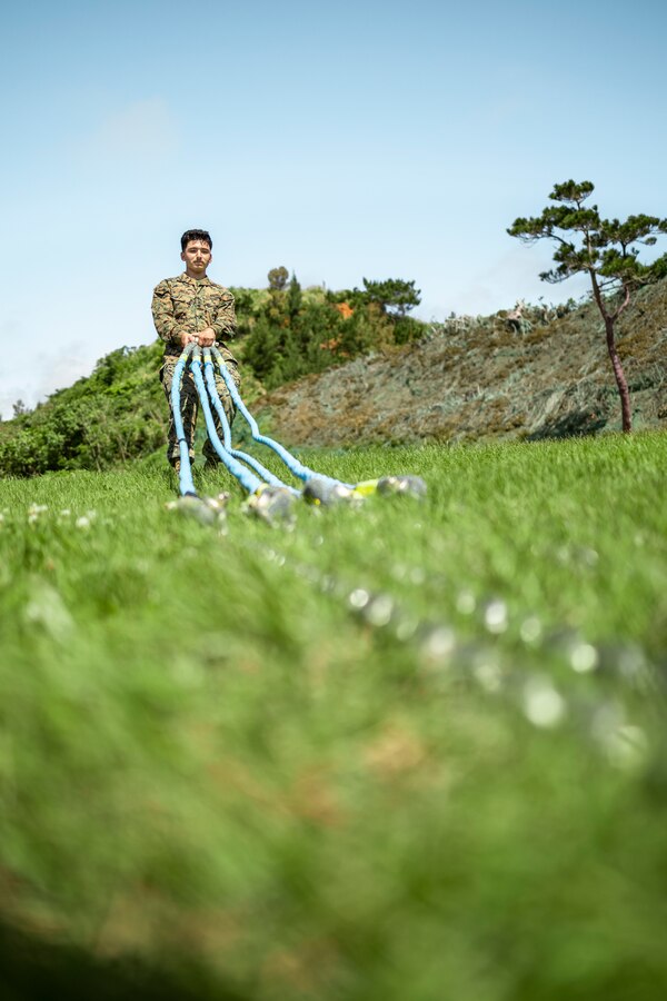 U.S. Marine Corps Lance Cpl. Billy Molina, a landing support specialist with 3rd Landing Support Battalion, 3rd Marine Logistics Group, drags detached slings from a container at Kin Blue, Okinawa, Japan, April 12, 2022. HMH-466 and 3rd Landing Support Battalion, 3rd Marine Logistics Group, conducted ship-to-shore movements to offload gear in support of redeployment from Balikatan 22, an annual joint force exercise in the Republic of the Philippines. (U.S. Marine Corps photo by Cpl. Terry Wong)