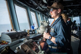 Ensign Joel Smith stands watch during a Strait of Malacca transit aboard the Arleigh Burke-class guided-missile destroyer USS Momsen (DDG 92).
