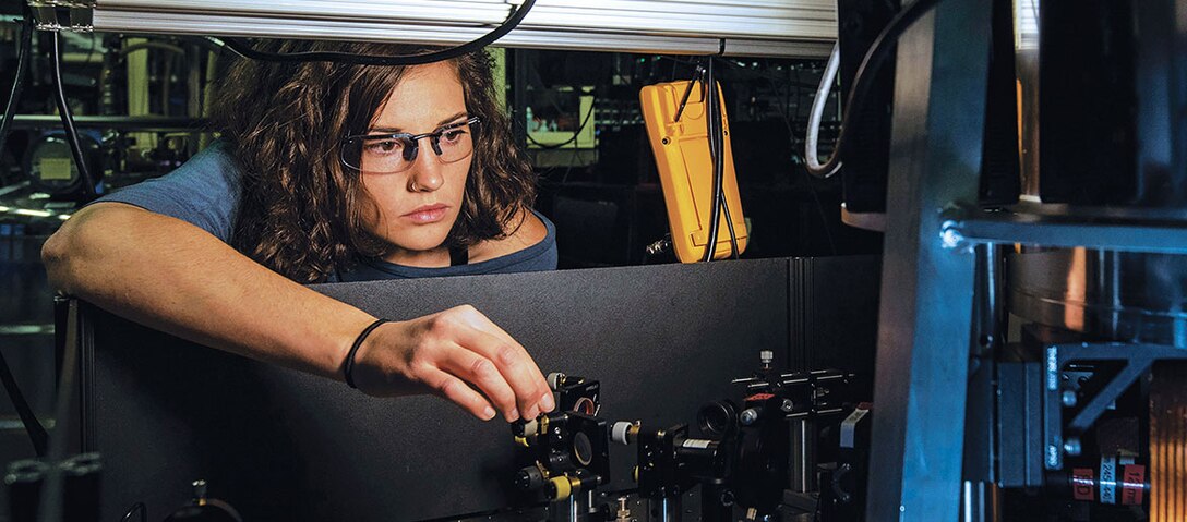 National Institute of Standards and Technology physicist Katie McCormick adjusts mirror to steer laser beam used to cool trapped beryllium ion, as part of efforts to improve quantum measurements and quantum computing, October 26, 2018