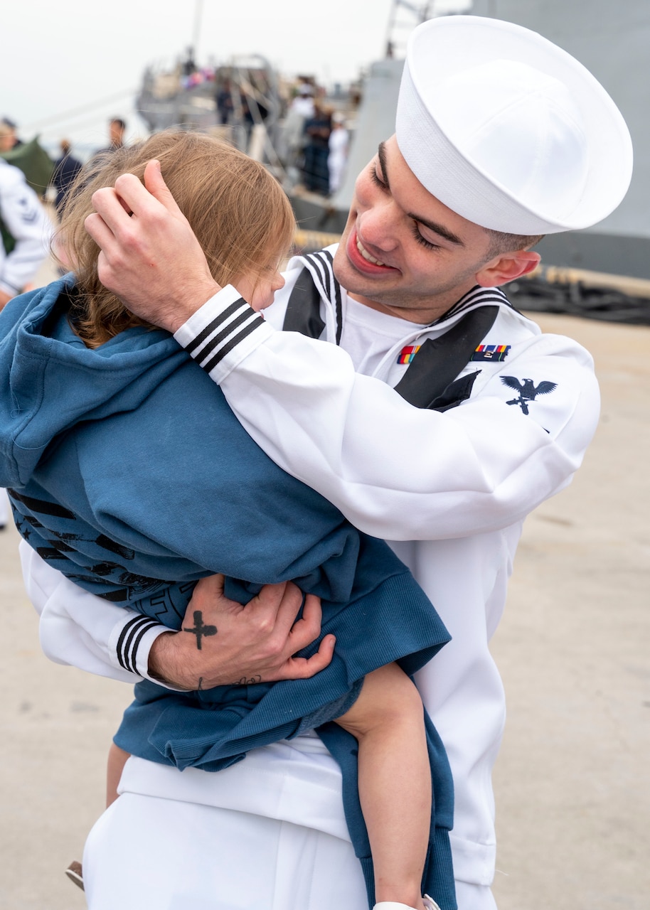 NORFOLK (April 16, 2022) - A Sailor assigned to the Arleigh Burke-class guided-missile destroyer USS Mitscher (DDG 57), embraces his daugther after the ship's return to homeport, Naval Station Norfolk, April 16. Mitscher deployed to the European theater of operations and participated in a range of maritime activities in support of Naval Forces Europe and NATO Allies. (U.S. Navy photo by Mass Communication Specialist 1st Class Ryan Seelbach)