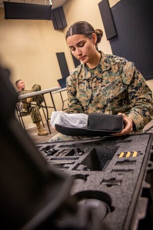 A marine removes gear from a bag.