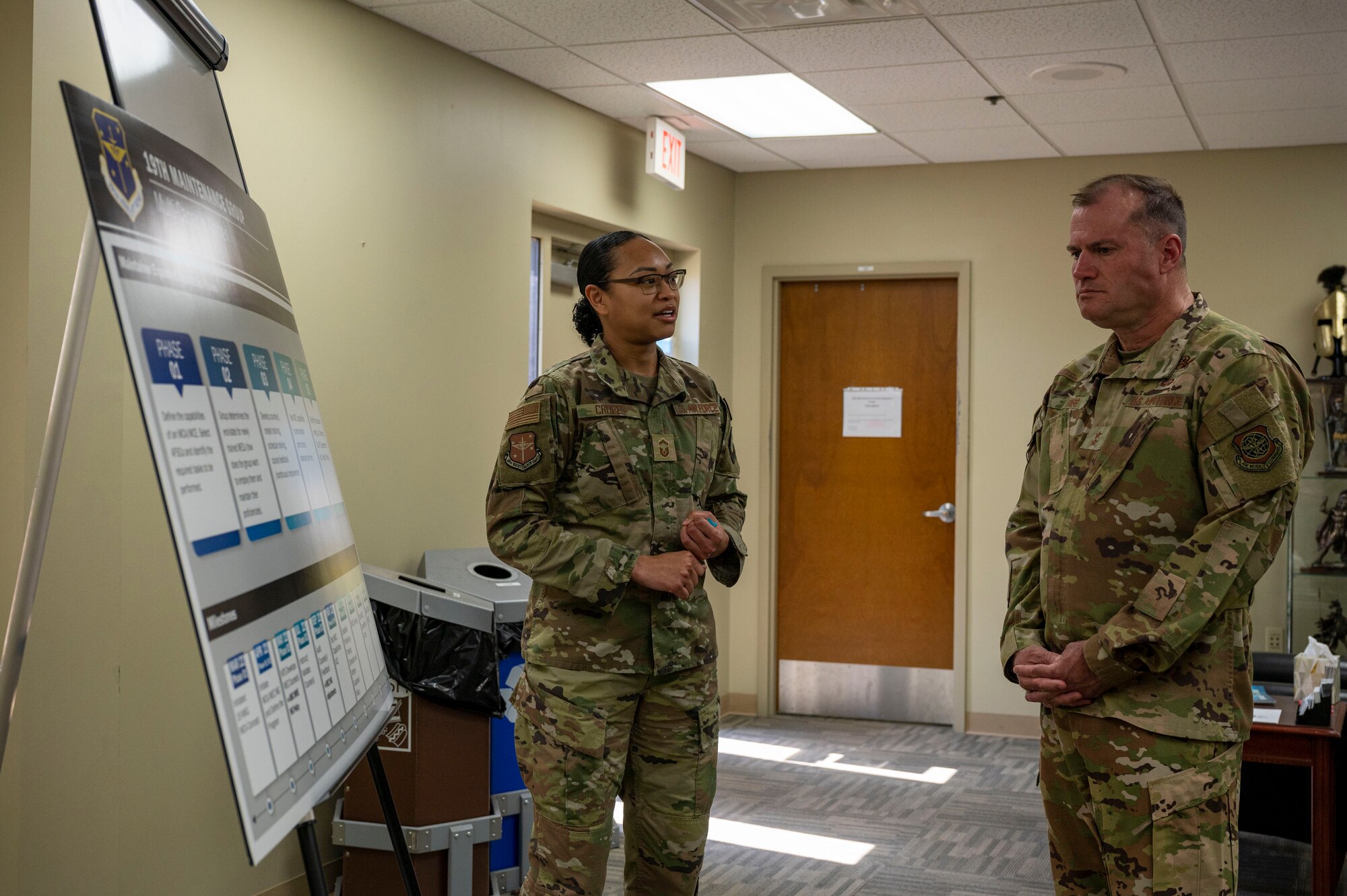 Senior Master Sgt. Dominique Cropes, 19th Maintenance Group training senior enlisted leader, left, gives a brief to Maj. Gen. Kenneth Bibb, 18th Air Force commander, right, during a visit to Little Rock Air Force Base