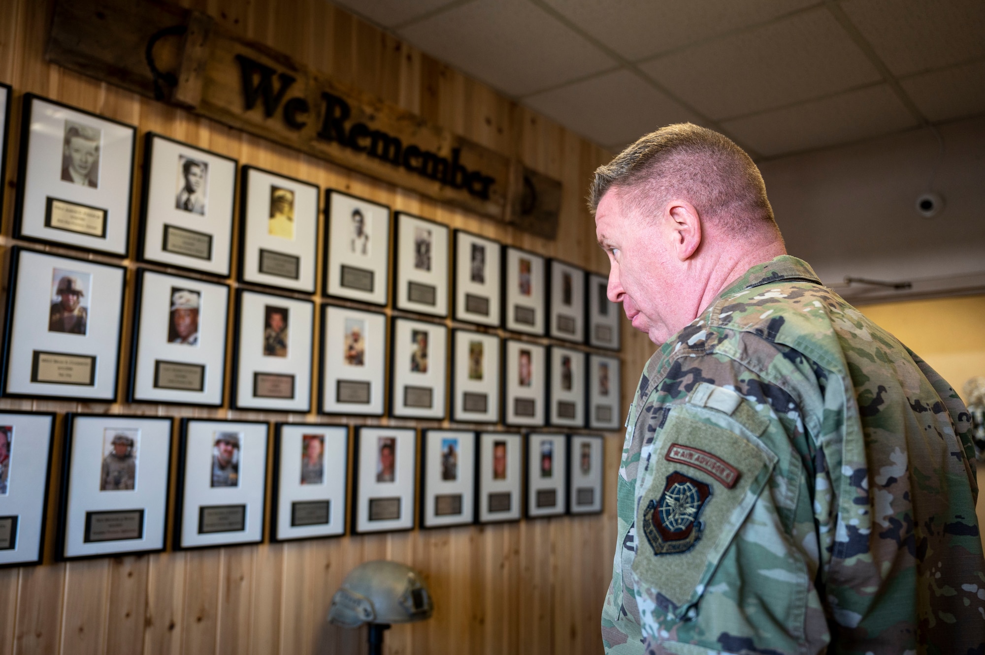 Chief Master Sgt. Chad Bickley, 18th Air Force command chief, observes a wall dedicated to fallen explosive ordnance disposal technicians