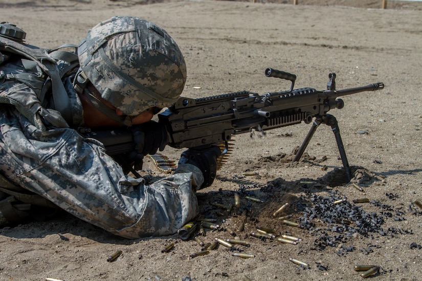 Un soldado yace en el suelo con un rifle en posición de tiro.