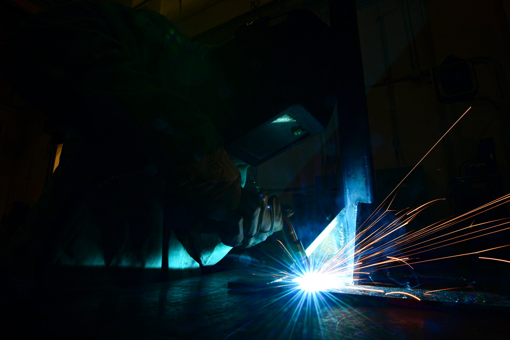 An Airman welds metal together.