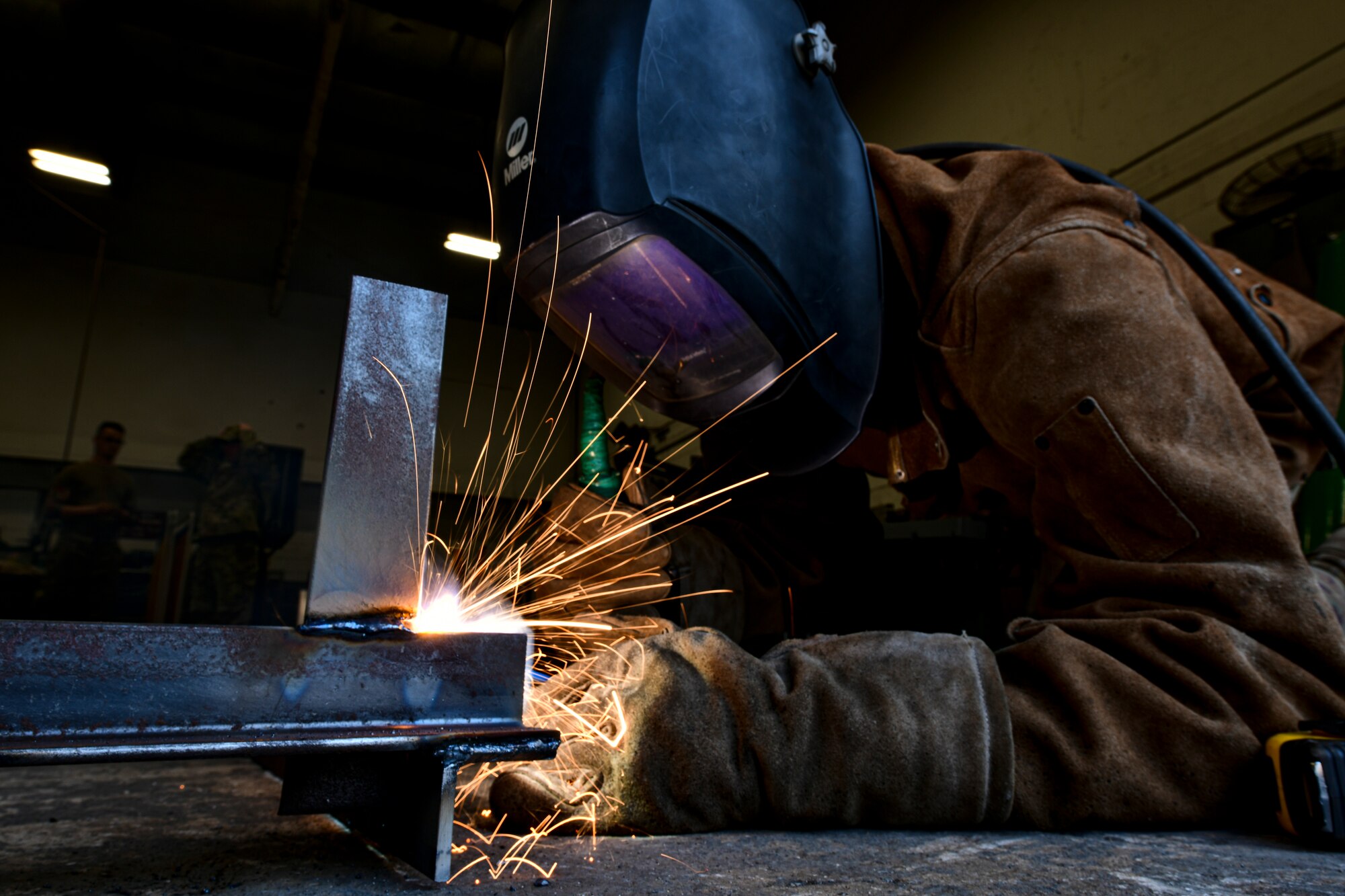 An Airman welds metal together.