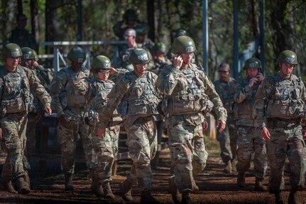 Soldiers in uniform and helmets walk together at Basic Combat Training.