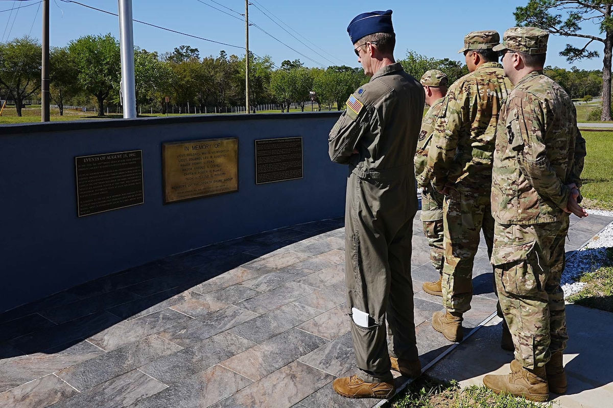 Airmen view a memorial outside.