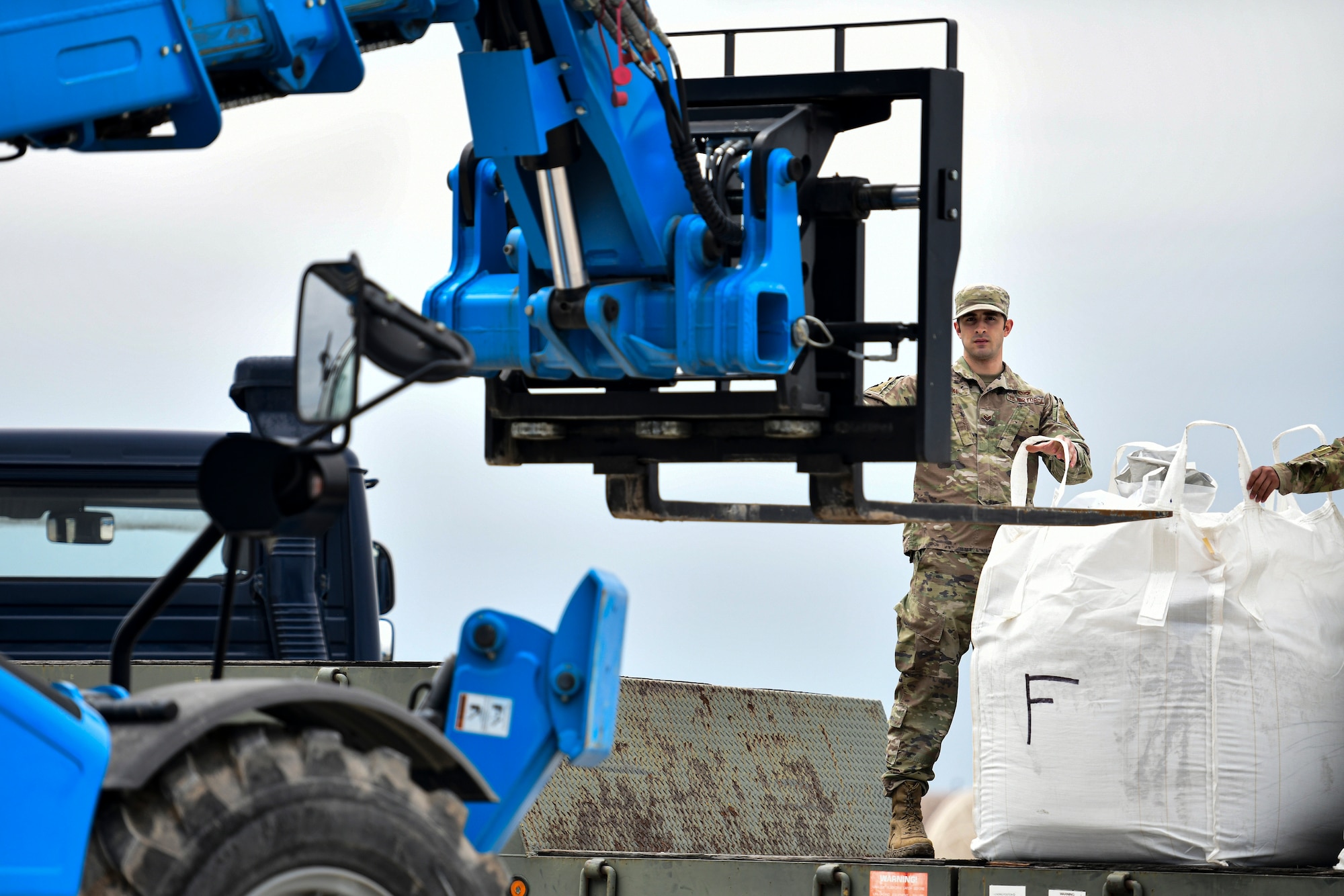 An Airman guides a forklift.