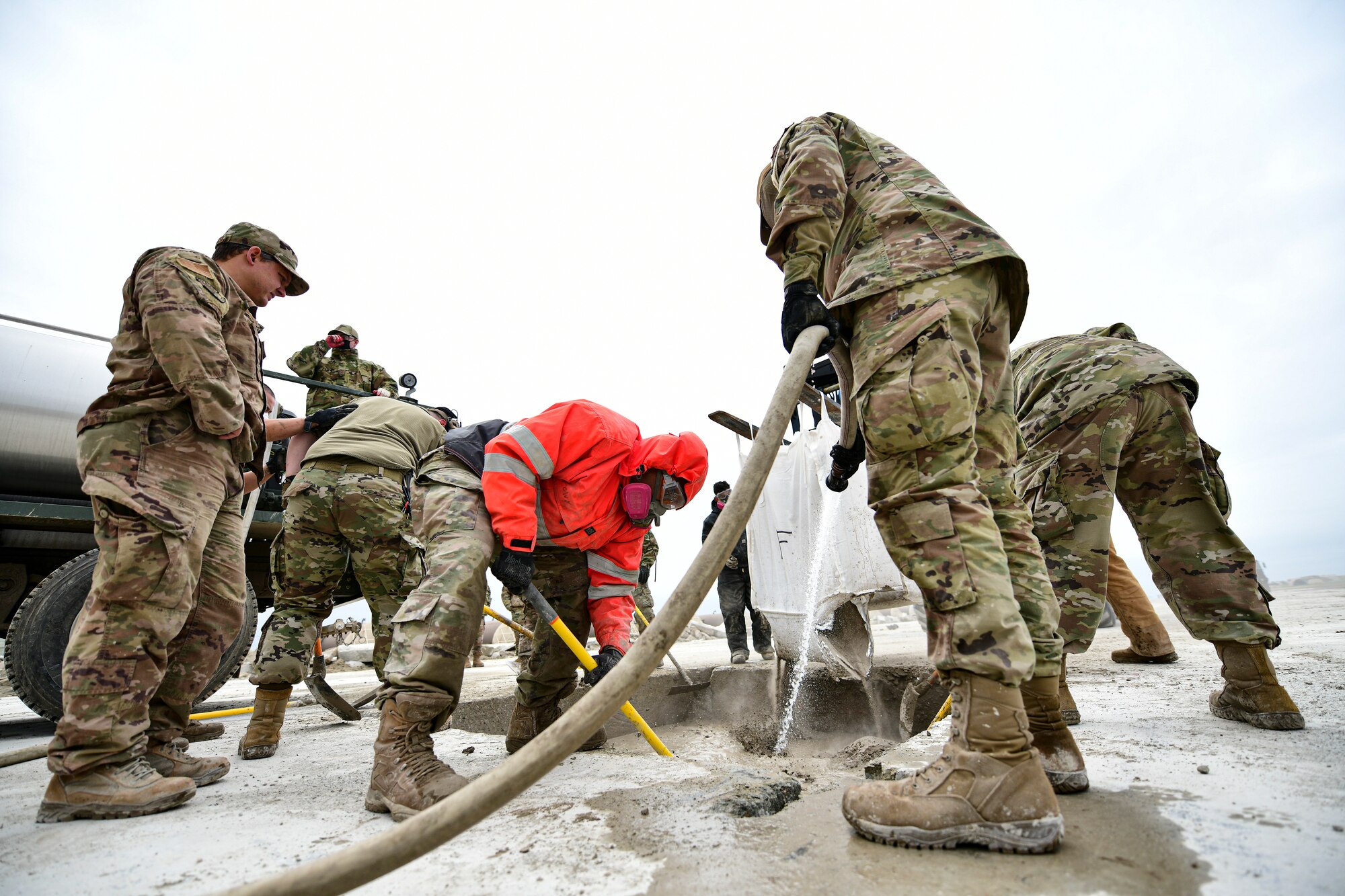 Airmen mix concrete.