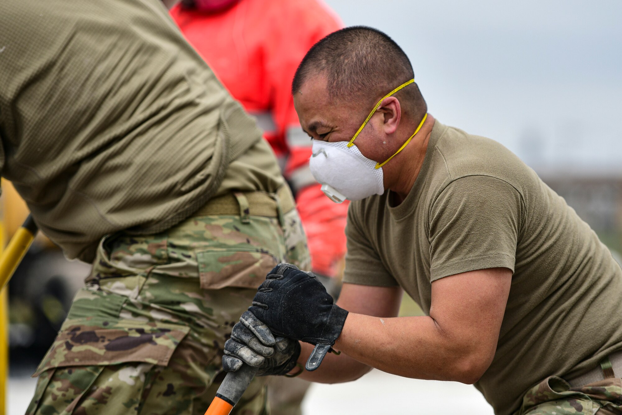 An Airman mixes concrete.