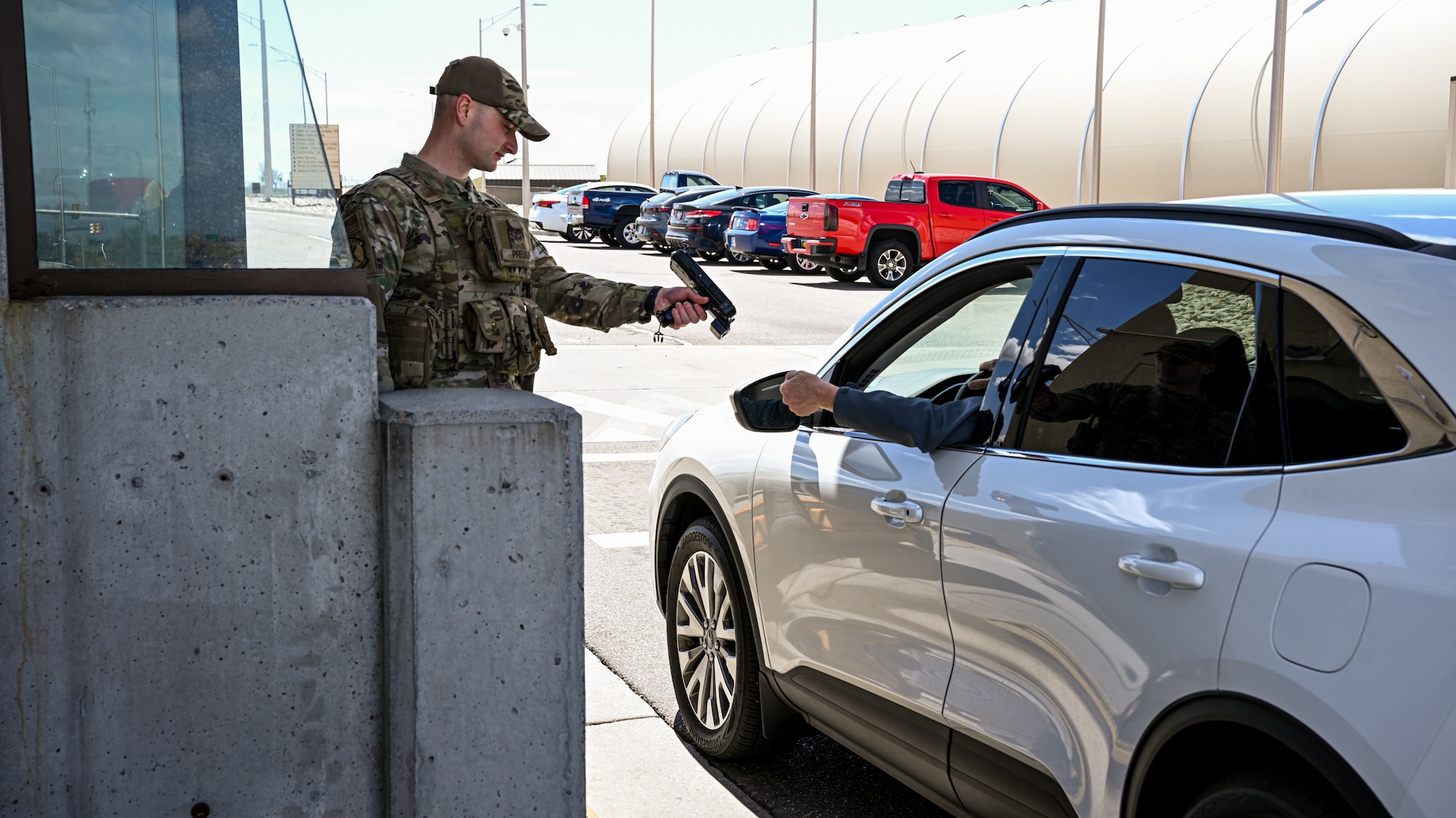 Staff Sgt. Isaac Preuss, 75th Security Forces Squadron, scans an identification card of the driver of a vehicle.
