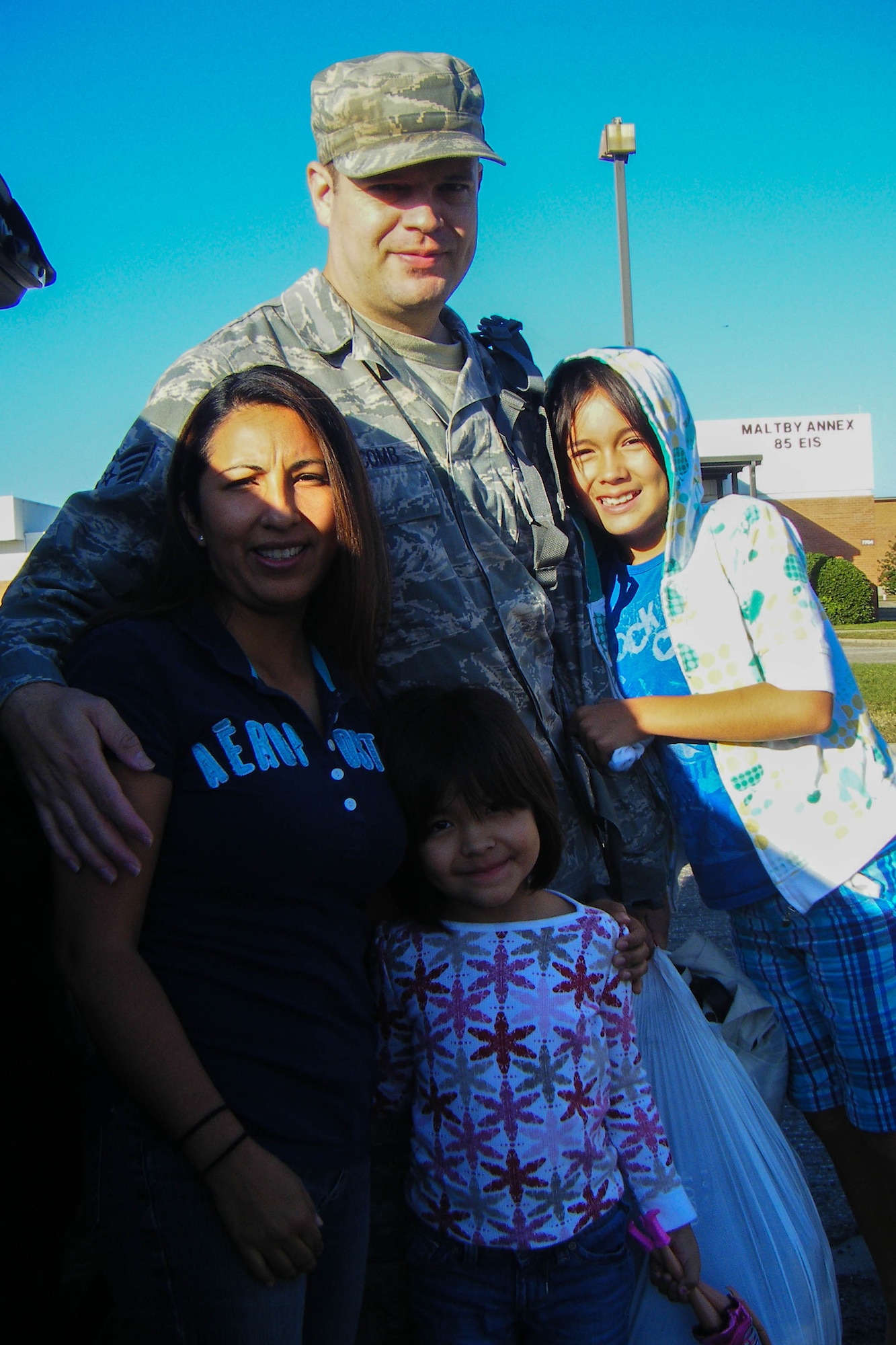 Holcomb hugging his wife and daughters