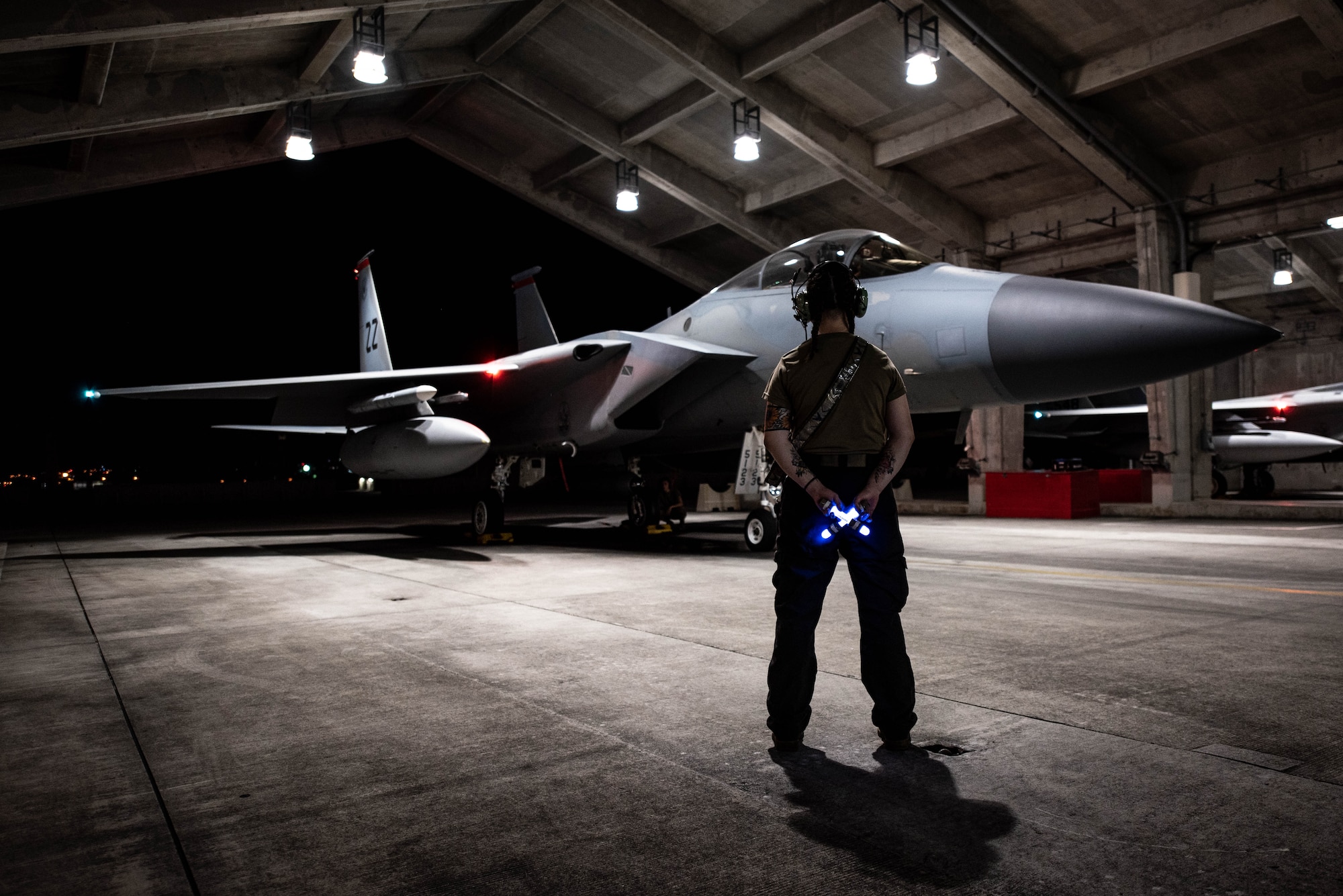 Senior Airman Allyssa Helman, 44th Aircraft Maintenance Unit crew chief, prepares to marshal an F-15C Eagle onto the flightline for Red Flag-Alaska at Kadena Air Base, Japan, April 15, 2022. Red Flag-Alaska is a Pacific Air Forces-directed field training exercise focused on improving the combat readiness of U.S. and international forces and provides training for units preparing for air and space expeditionary force tasking. (U.S. Air Force photo by Airman 1st Class Sebastian Romawac)