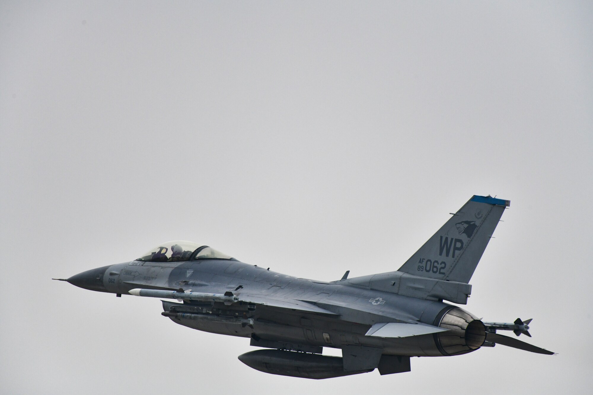 A jet flies over a base.