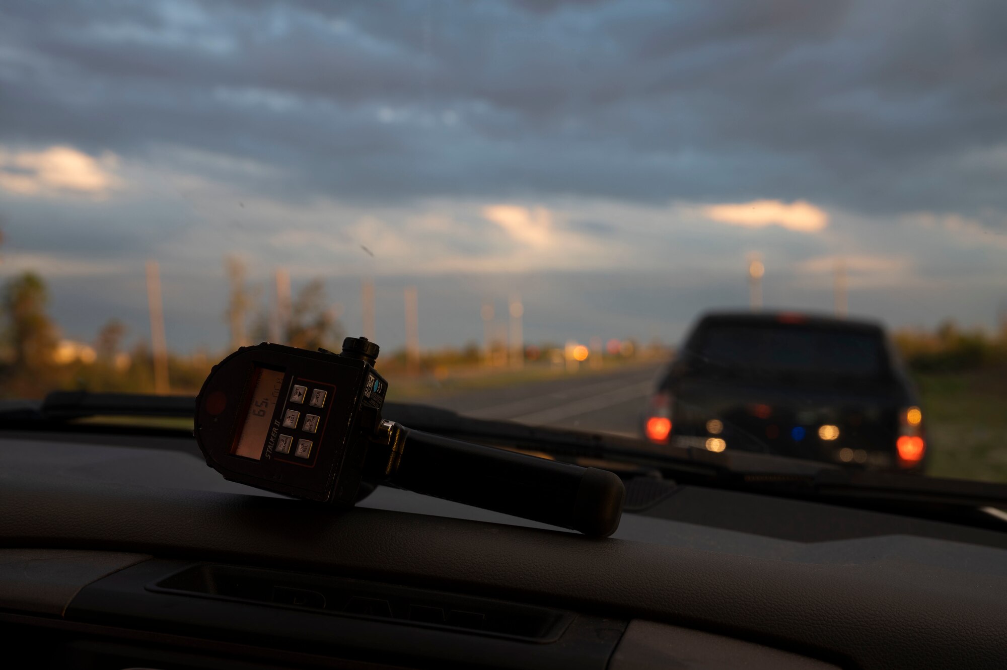 A radar gun lying on the dashboard of a police vehicle