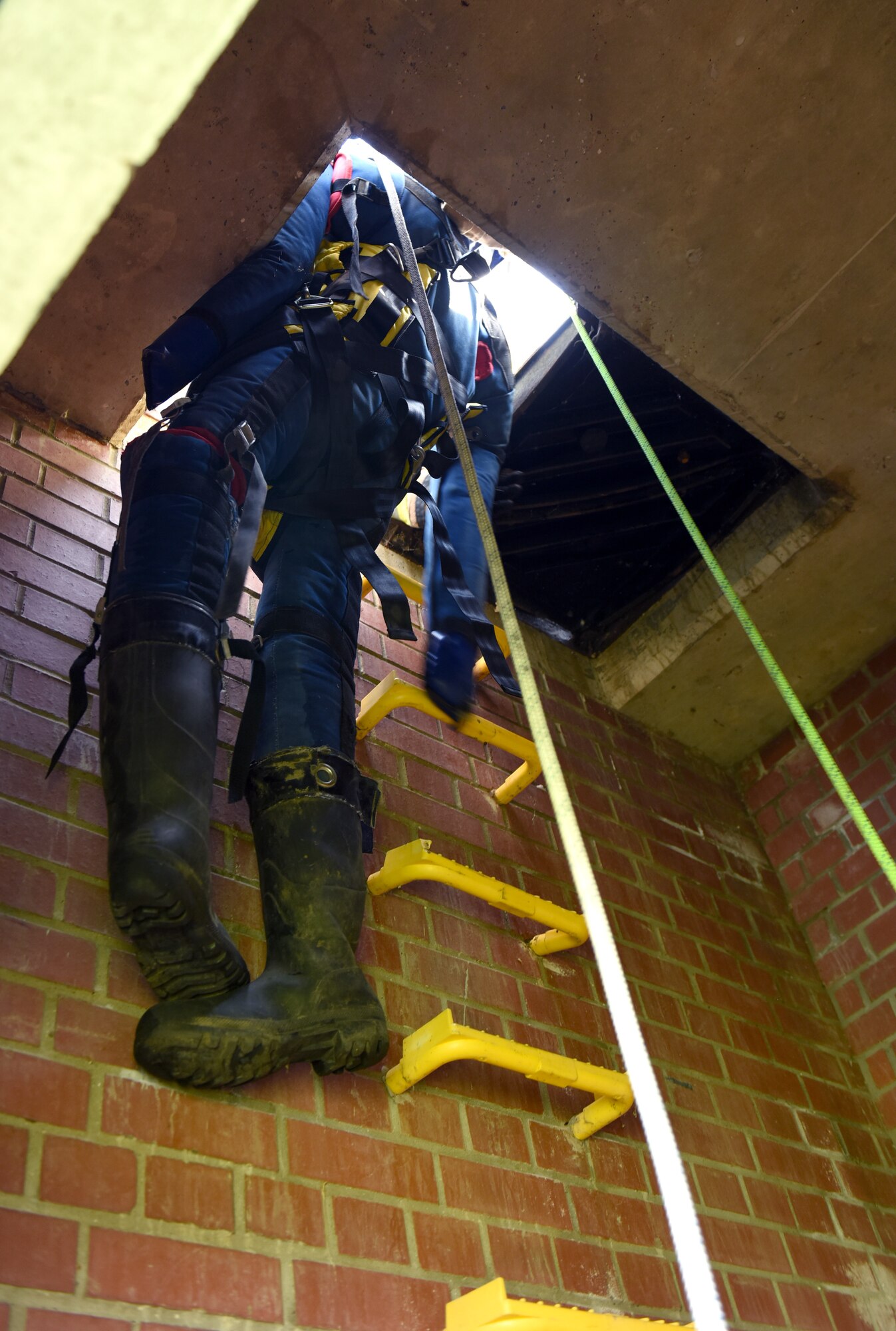 A simulated victim gets hoisted out of a confined space on belay and safety lines during confined space training conducted by the 100th Civil Engineer Squadron Fire Department at Royal Air Force Mildenhall, England, April 14, 2022. The fire department conducts a full confined-space drill at least four times a year for firefighters to meet training requirements. It’s vital for them to stay proficient with confined space and rescue to ensure they can successfully respond to real-world emergencies. (U.S. Air Force photo by Karen Abeyasekere)
