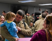An Airman reunites with his family after his return from Winter Break 2022 at Minot Air Force Base, North Dakota, April 19, 2022. After being away for months participating in a BTF, Minot Airmen finally return home. (U.S. Air Force Photo by Airman 1st Evan J. Lichtenhan)