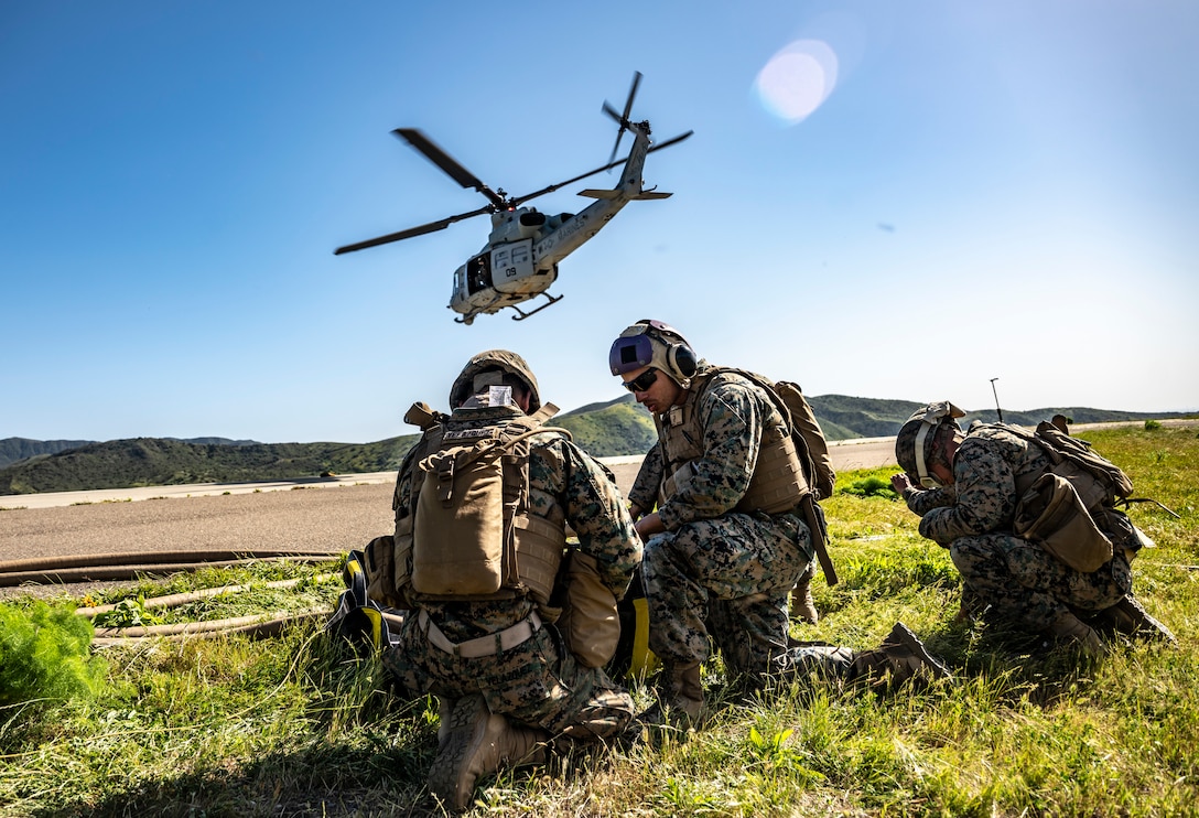 U.S. Reserve Marine bulk fuel specialists with Marine Wing Support Squadron 473, 4th Marine Aircraft Wing, prepare a fuel line to replenish a UH-1Y Venom at a forward arming and refueling point at Marine Corps Base Camp Pendleton, Calif., April 8, 2022. A FARP extends the combat radius of aircraft and reduces their turn-around time to the objective.