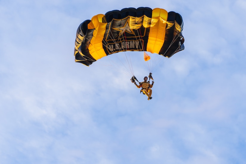 Army Soldier in yellow jumpsuit parachutes.