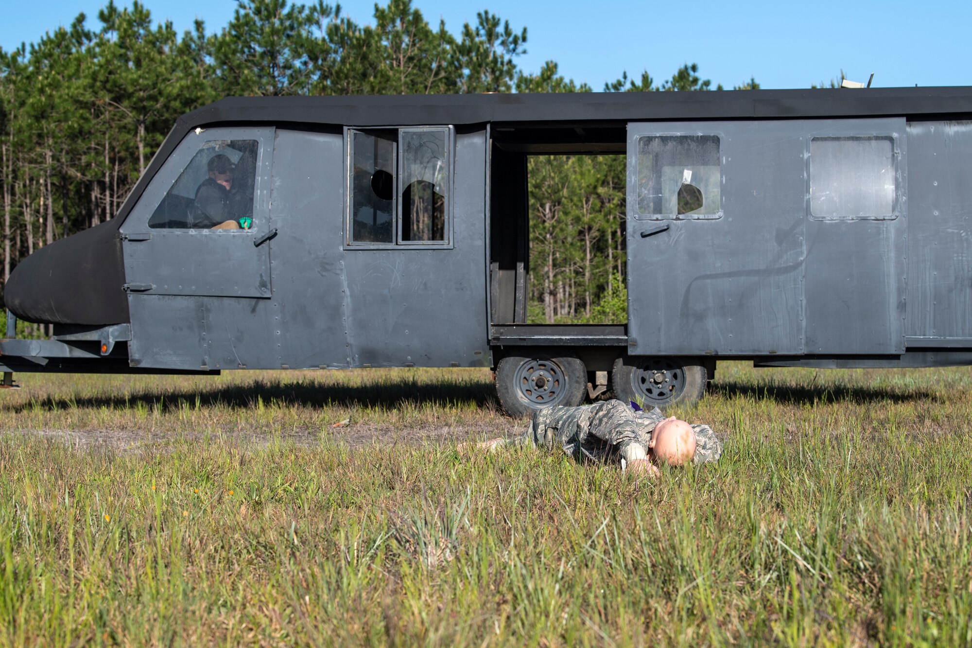 A simulated helicopter and downed aircrew lay in a field as part of a Major Accident Response Exercise in Echols County, Georgia, April 19, 2022. A major accident would require response from a multitude of agencies including first responders, the safety office, maintenance squadrons and security forces while establishing an emergency operations center. (U.S. Air Force photo by Airman 1st Class Deanna Muir)