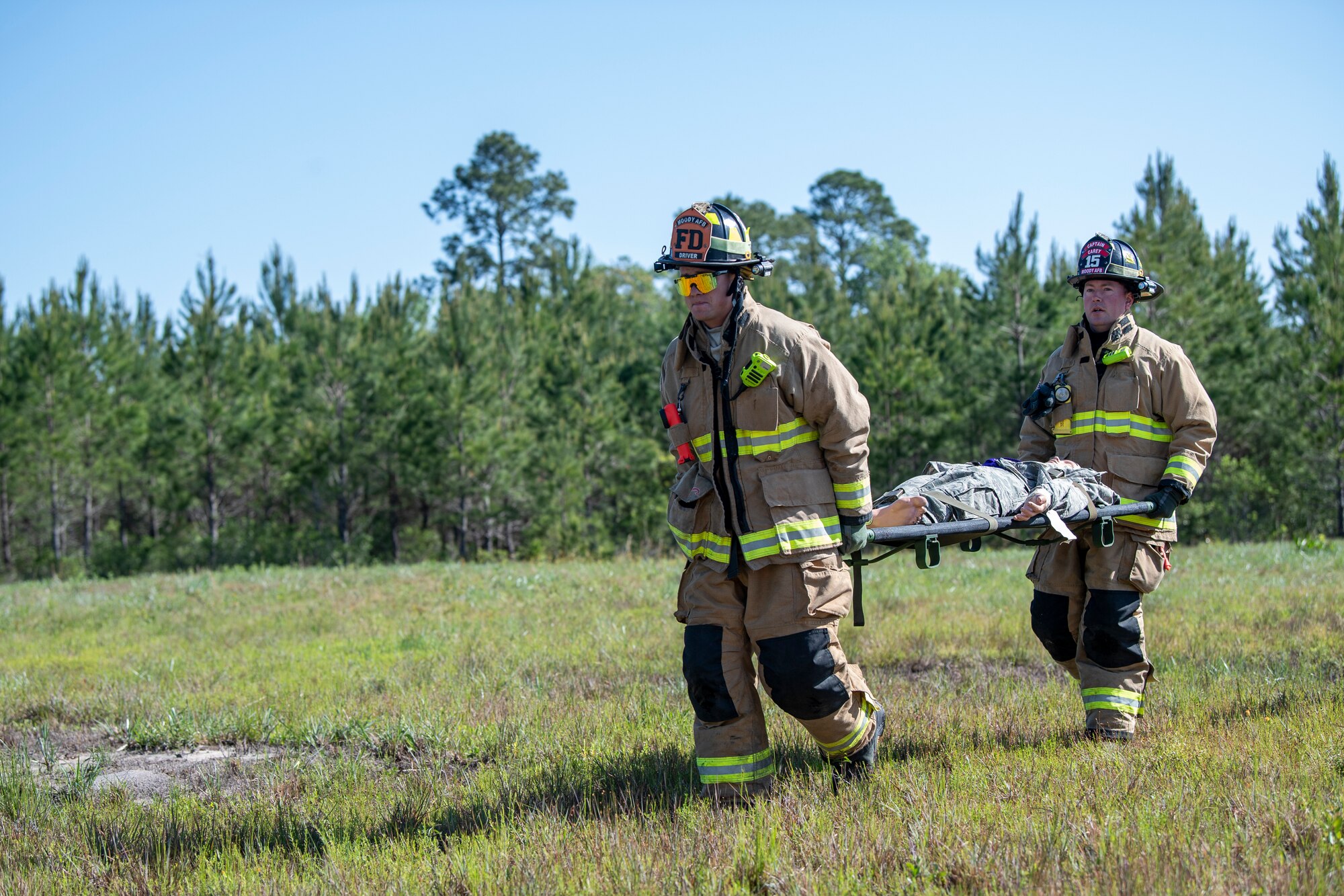 U.S. Air Force Senior Airman Zachary Mabee, 23rd Civil Engineer Squadron driver operator, left, and Donald Carey, 23rd CES lead firefighter, carry a dummy during a Major Accident Response Exercise in Echols County, Georgia, April 19, 2022. This exercise, which simulated a helicopter crash off base with downed aircrew, tested communication and response of Airmen around Moody in a major accident situation. (U.S. Air Force photo by Airman 1st Class Deanna Muir)