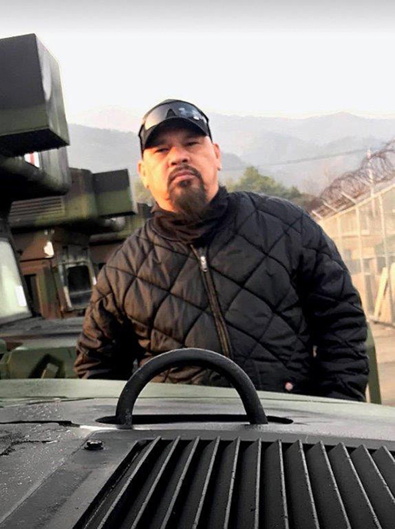 A man poses behind a humvee.