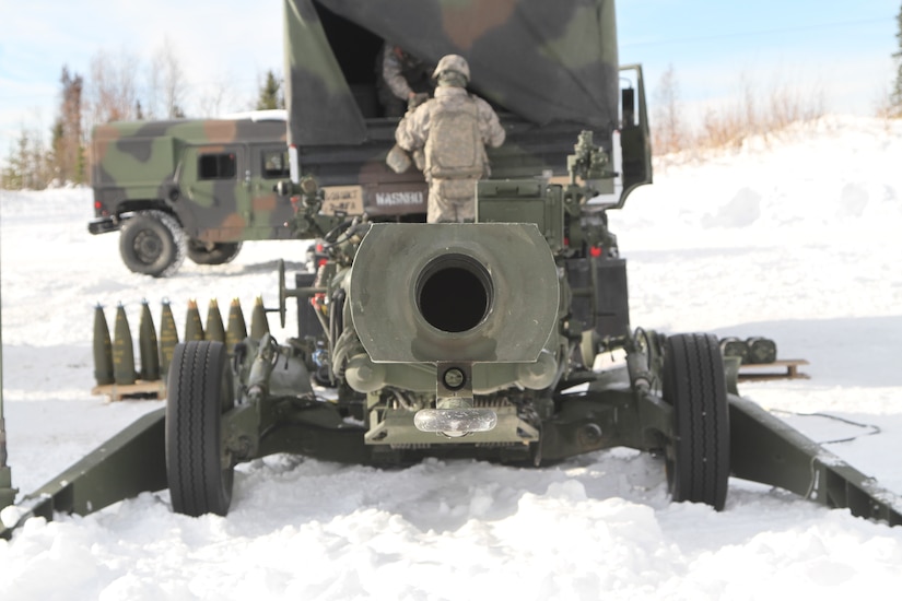 A large gun sits in the snow.