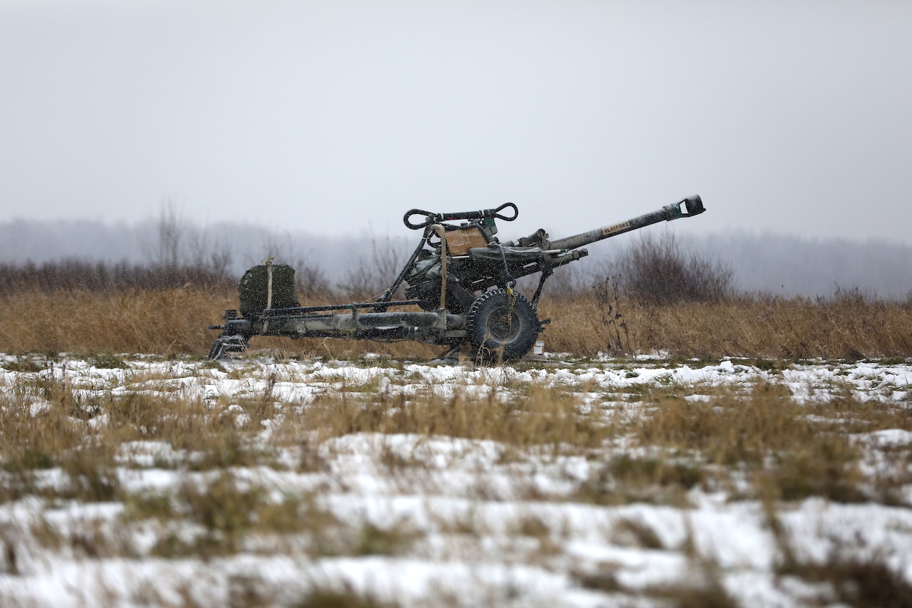 A large gun sits in a field.