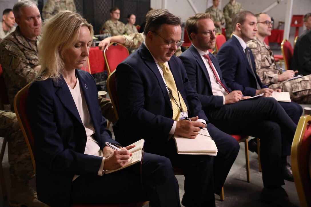 Attendees take notes during the Ambassadors Day event at Union III forward operating base in Baghdad, Iraq, April 21, 2022. During the CJTF-OIR-hosted event, representatives from more than 25 Coalition countries discussed the CJTF-OIR mission and broad efforts to tackle enduring regional security and stability challenges. (U.S. Army photo by Staff Sgt. Bree-Ann Ramos-Clifton)
