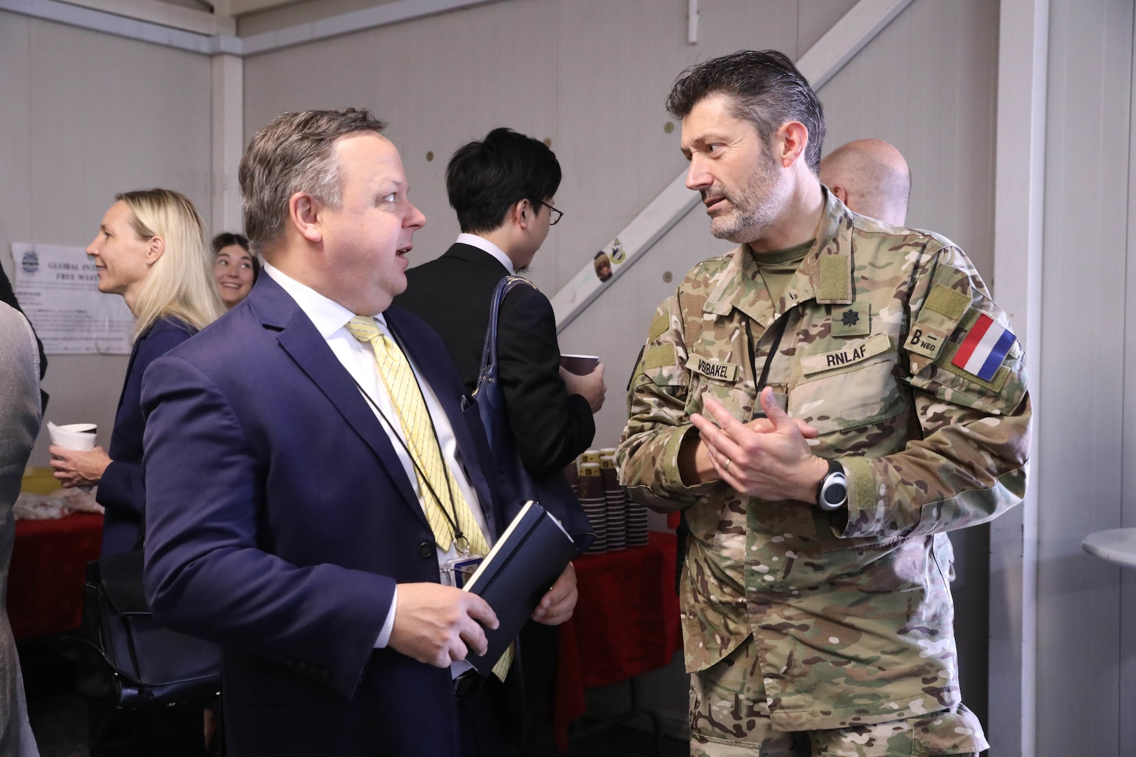 Daniel Wartko, Political Advisor for Combined Joint Task Force - Operation Inherent Resolve (CJTF - OIR) and Lt. Col. Johan Verbakel, the executive officer of the Directorate of Interagency and Civil Engagement, hold a discussion during the Ambassadors Day event at Union III forward operating base in Baghdad, Iraq, April 21, 2022. During the CJTF-OIR-hosted event, representatives from more than 25 Coalition countries discussed the CJTF-OIR mission and broad efforts to tackle enduring regional security and stability challenges. (U.S. Army photo by Staff Sgt. Bree-Ann Ramos-Clifton)