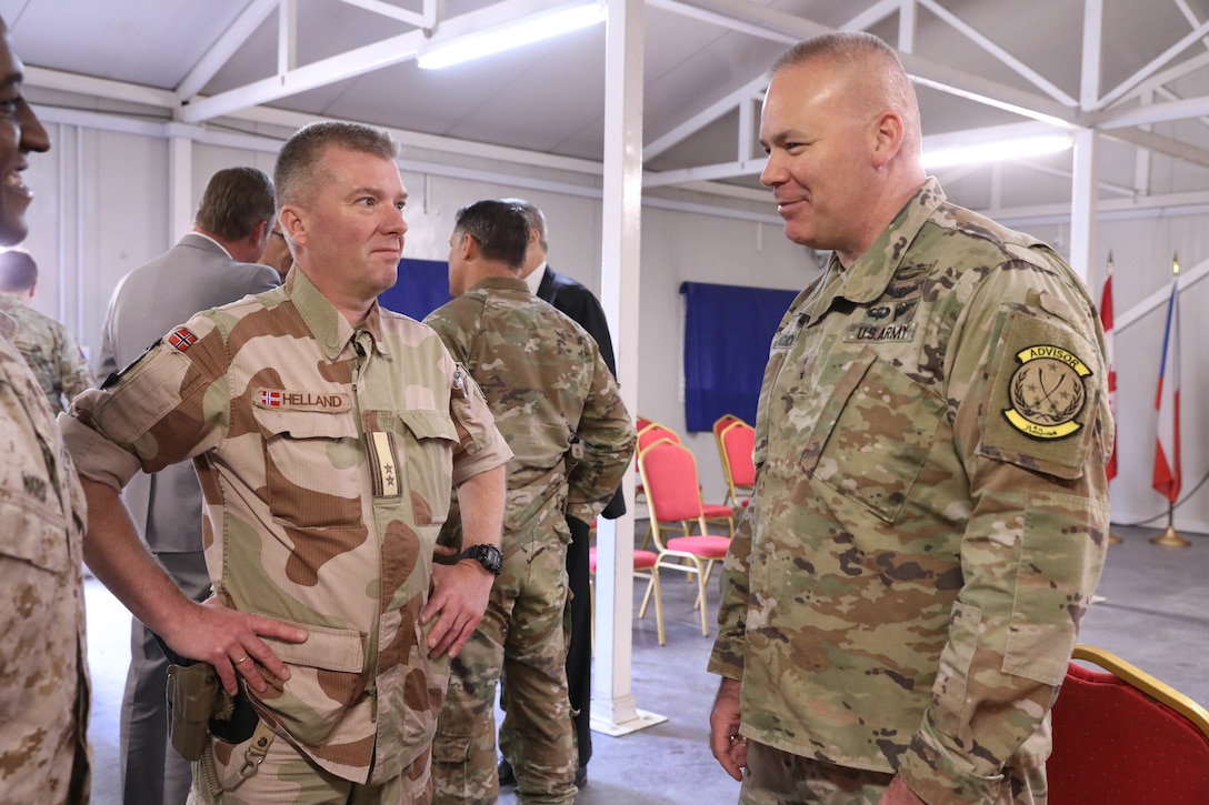 Brig. Gen. Nick Ducich, director of the Military Advisory Group, Combined Joint Task Force - Inherent Resolve (CJTF - OIR), right, and Lt. Col. Rolf Helland, CJTF – OIR Norway Senior national representative, left, hold a discussion during the Ambassadors Day event at Union III forward operating base in Baghdad, Iraq, April 21, 2022. During the CJTF-OIR-hosted event, representatives from more than 25 Coalition countries discussed the CJTF-OIR mission and broad efforts to tackle enduring regional security and stability challenges. (U.S. Army photo by Staff Sgt. Bree-Ann Ramos-Clifton)