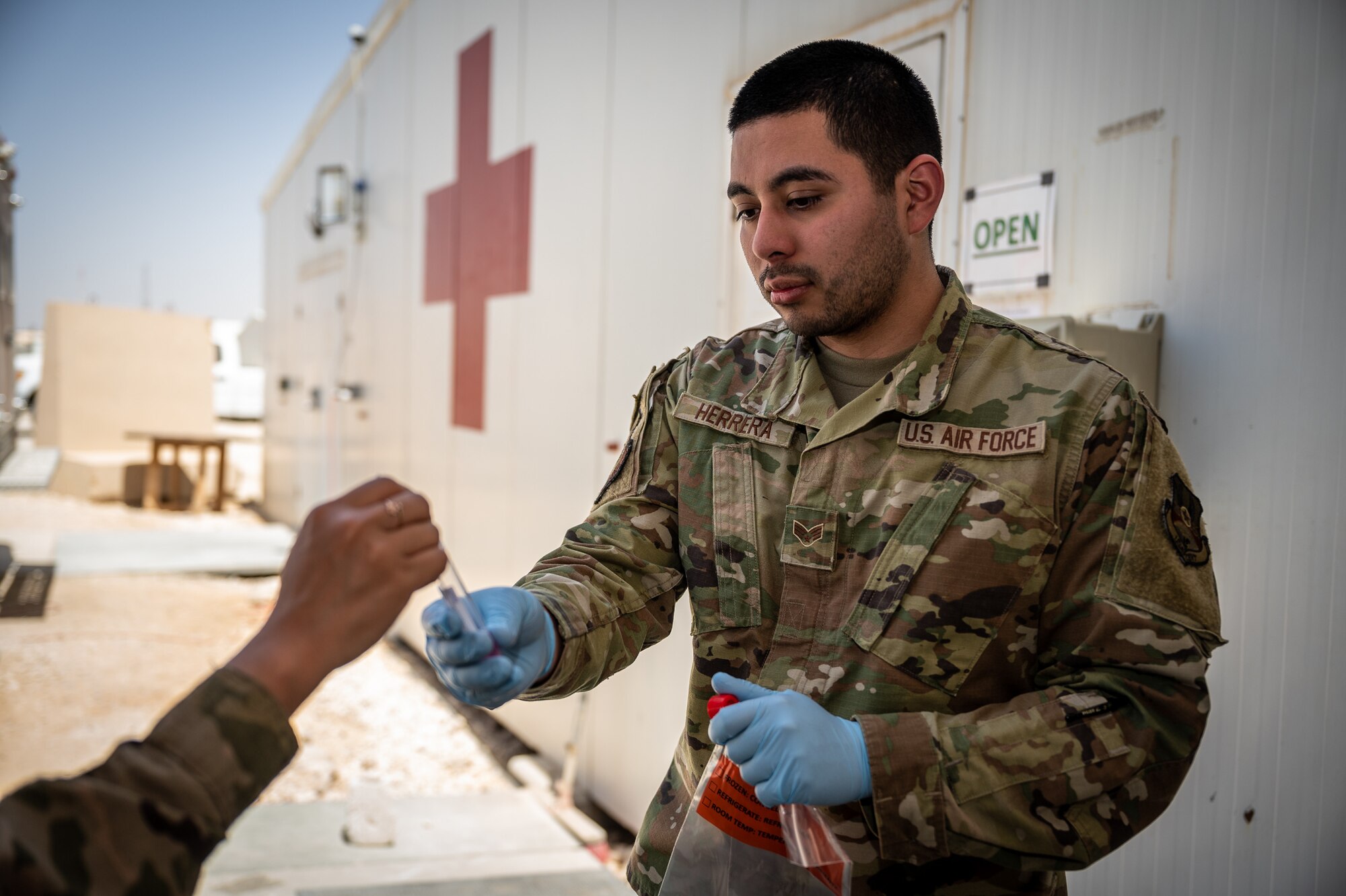 Senior Airman Michael Herrera, 332d Expeditionary Medical Group X-ray technician, administers a COVID-19 test to a 332d Air Expeditionary Wing Airman at an undisclosed location in Southwest Asia, April 15, 2022. Herrera supports COVID-19 testing as a multi-capable Airman although his primary job is as an X-ray technician. (U.S. Air Force photo by Master Sgt. Christopher Parr)