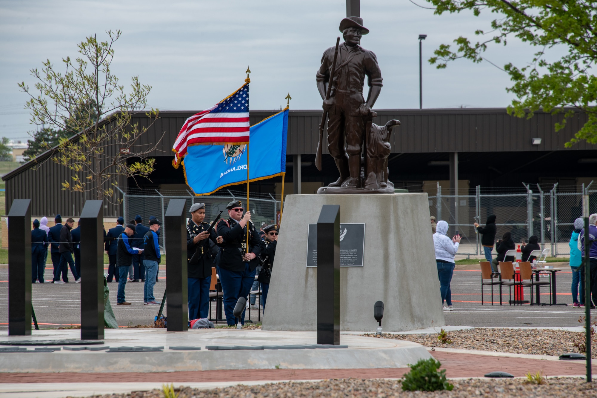 JROTC students march behind statue