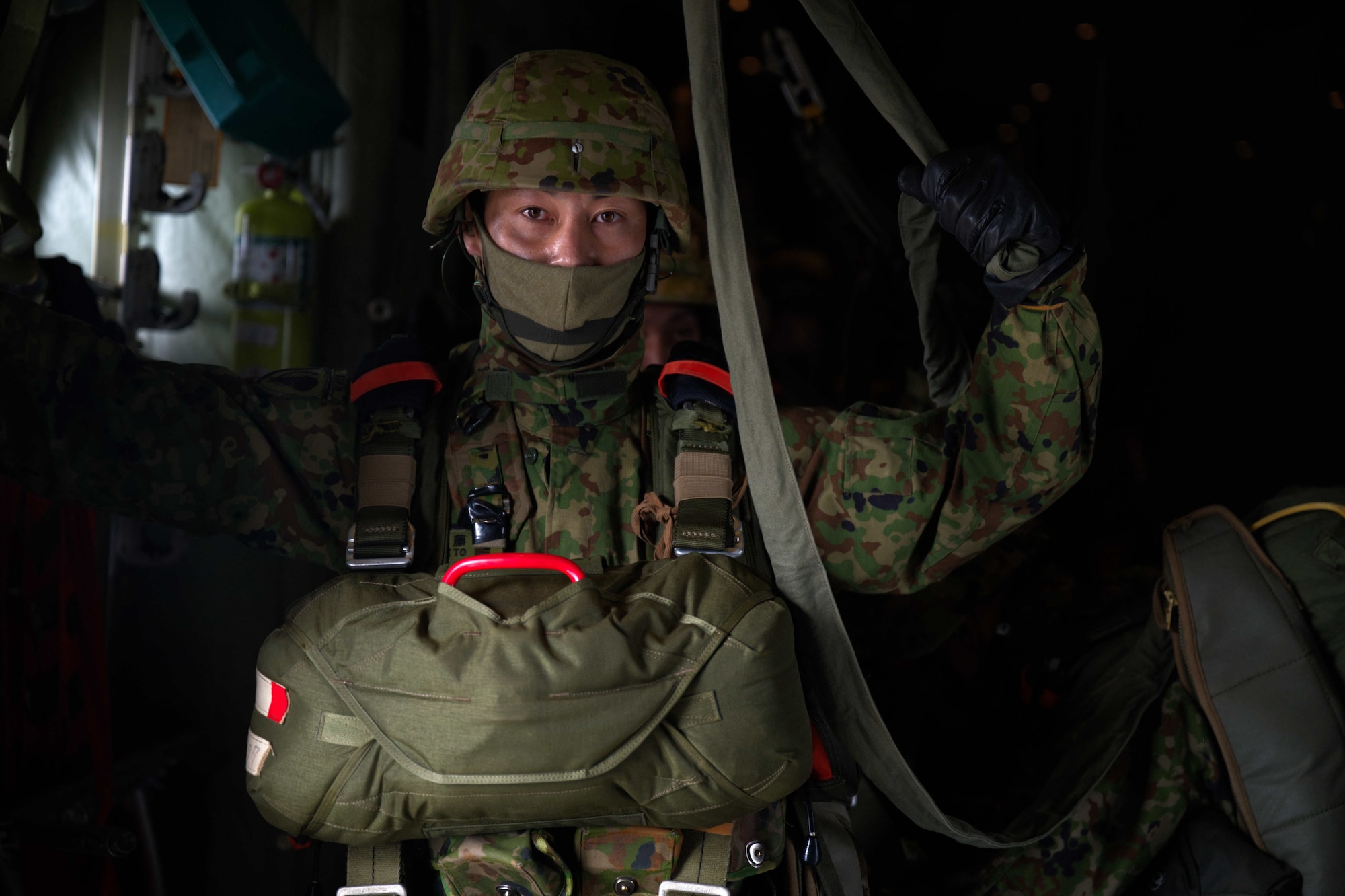 JGSDF member stands in a C-130J preparing to jump.