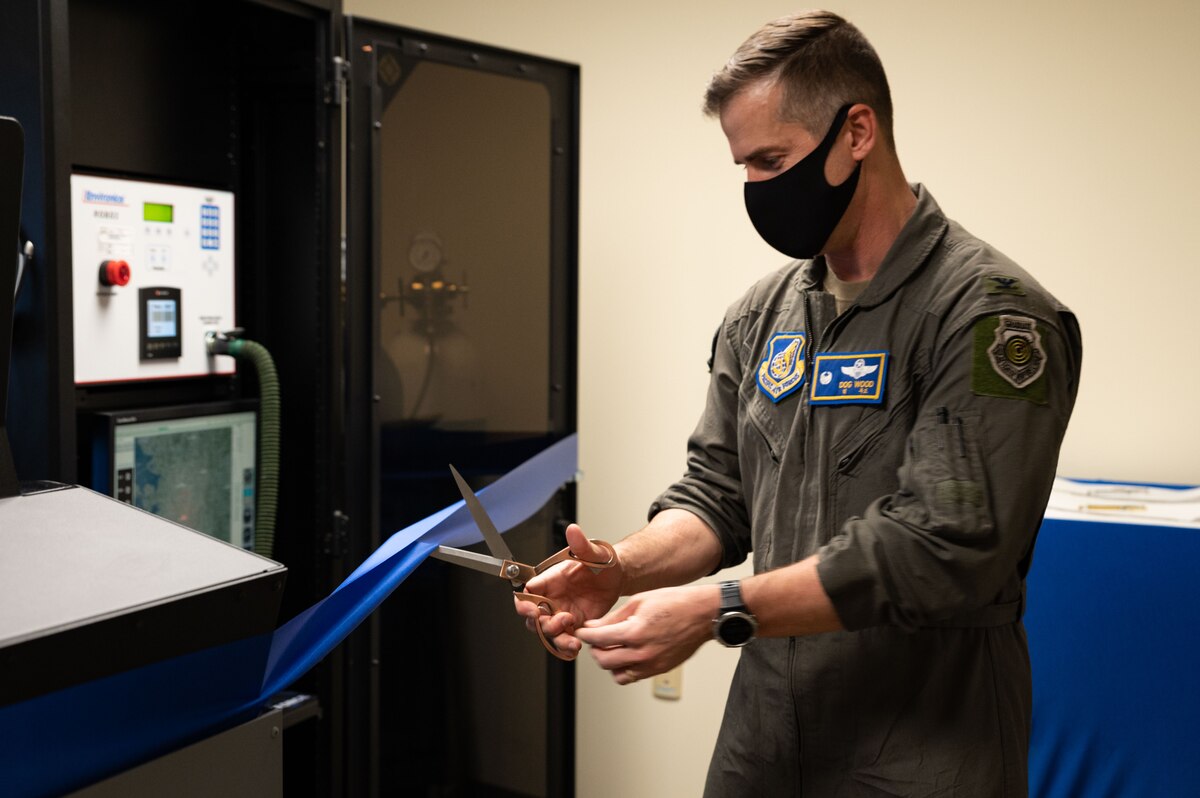 Col. Joshua Wood, 51st Wing commander, cuts a ribbon for the grand opening of a hypoxia familiarization trainer at Osan Air Base, Republic of Korea, April 1, 2022.