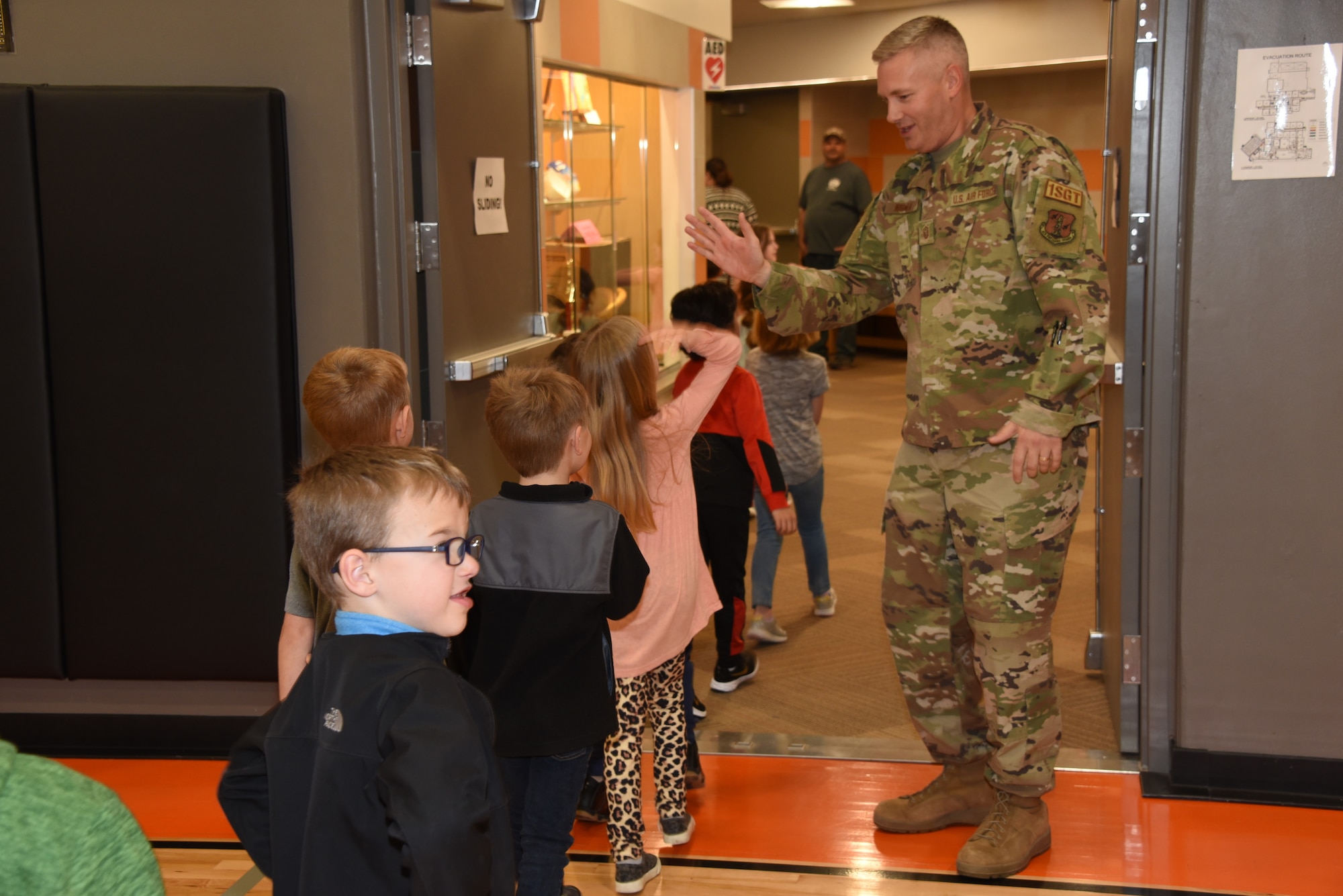 1st Sgt. Drew Wagner high fives students at a welcome home event in his honor at the Fort Calhoun Elementary School in Fort Calhoun, Neb., April 21, 2022, after his six-month deployment to Southwest Asia. Wagner is the school principal and has served in the Iowa Air National Guard for 20 years.