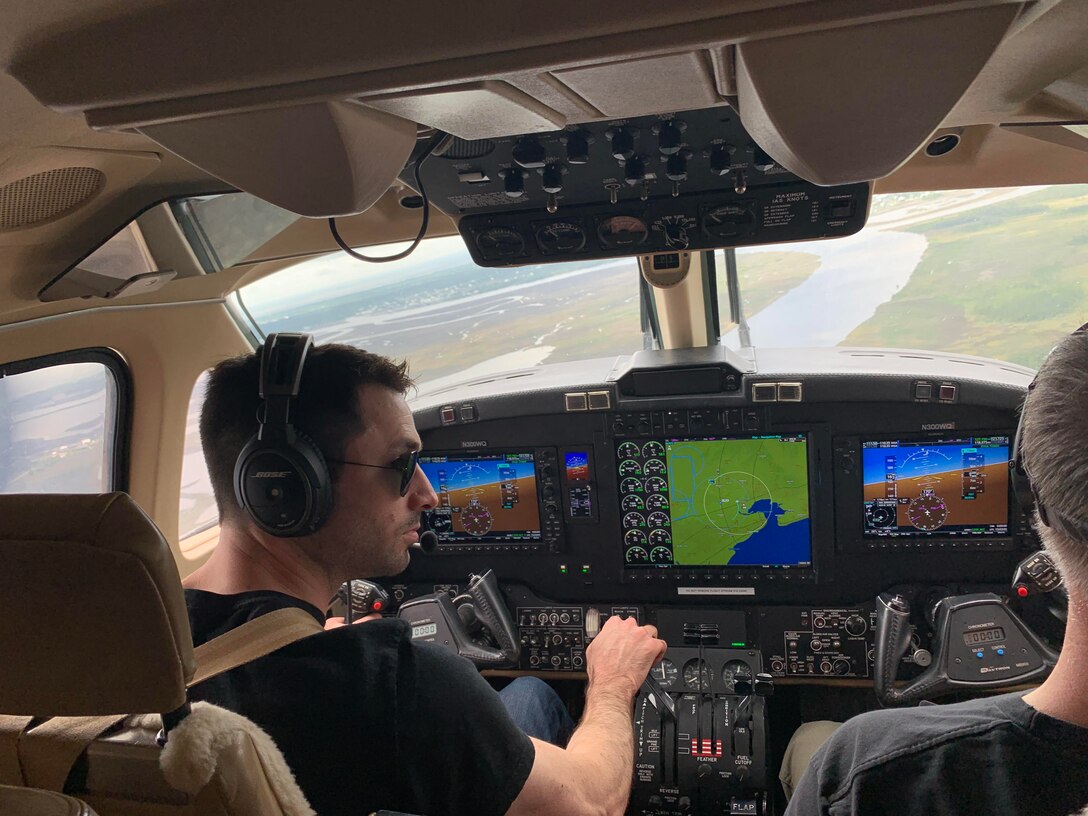 Nevo Dar Perl, pilot, and Mark Kickland, copilot, check the starboard side of the aircraft for other aircraft during a calibration flight over Stennis International Airport, Mississippi, April 18, 2022. While the pilots fly the aircraft, the sensor operator troubleshoots the lidar system to ensure quality data is collected during field operations. The Joint Airborne Lidar Bathymetry Technical Center of Expertise team collects information about the waterways and coastline to ensure U.S. Army Corps of Engineers’ project success and completion. (USACE photo by Christopher Carranza)
