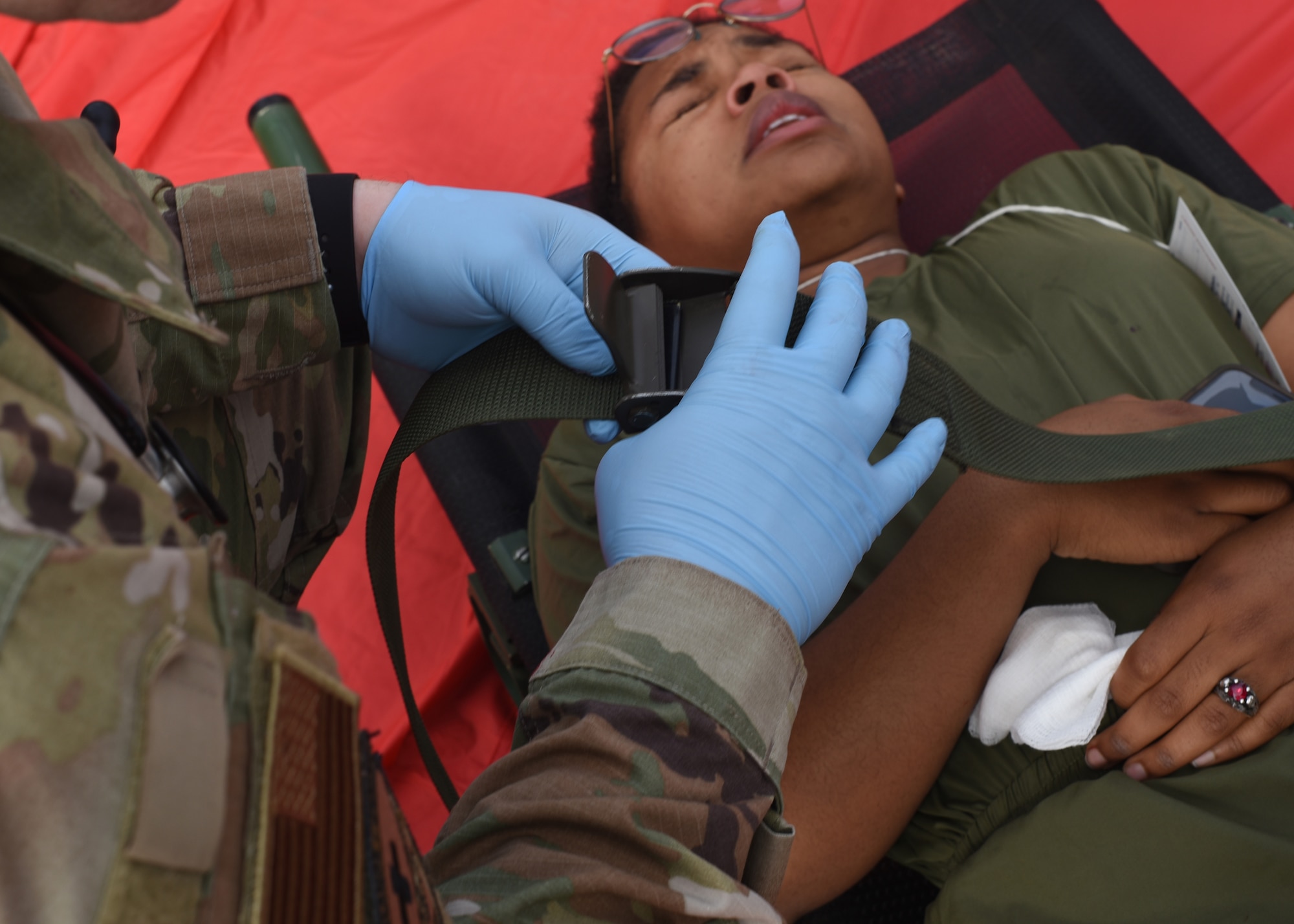A service member assigned to the 17th Medical Group straps a simulated victim to a stretcher during an active shooter exercise at Goodfellow Air Force Base, Texas, April 21, 2022. The exercise focused on 17th Training Wing readiness. (U.S. Air Force photo by Senior Airman Abbey Rieves)