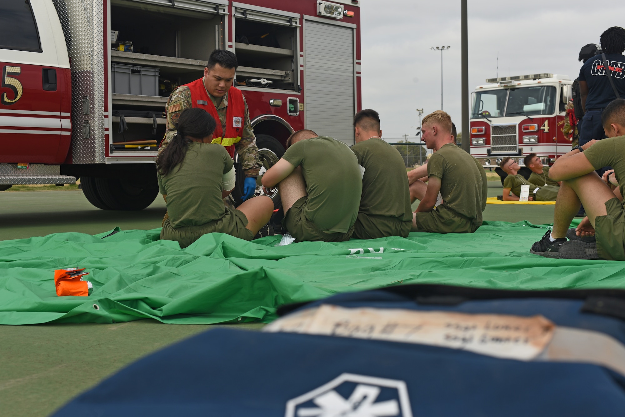 A service member assigned to the 17th Medical Group, assesses injuries of role-playing victims during an active shooter exercise at Goodfellow Air Force Base, Texas, April 21, 2022. More than 50 volunteer victims were either covered in stage blood, or exhibited different life or death ailments for the medical team to identify and treat during the base-wide exercise. (U.S. Air Force photo by Senior Airman Abbey Rieves)