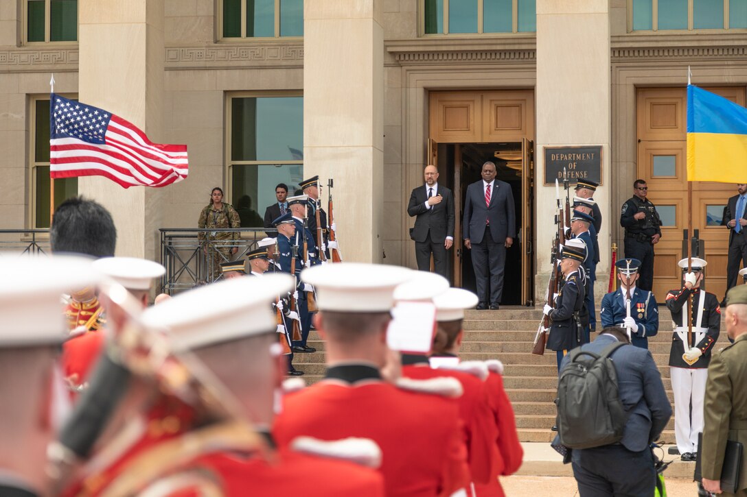 Ukrainian Prime Minister Denys Shmyhal stands with hand over heart next to Secretary of Defense Lloyd J. Austin III as "The President's Own" United States Marine Band performs the Ukrainian National Anthem during an enhanced cordon arrival ceremony at the Pentagon on April 21, 2022.