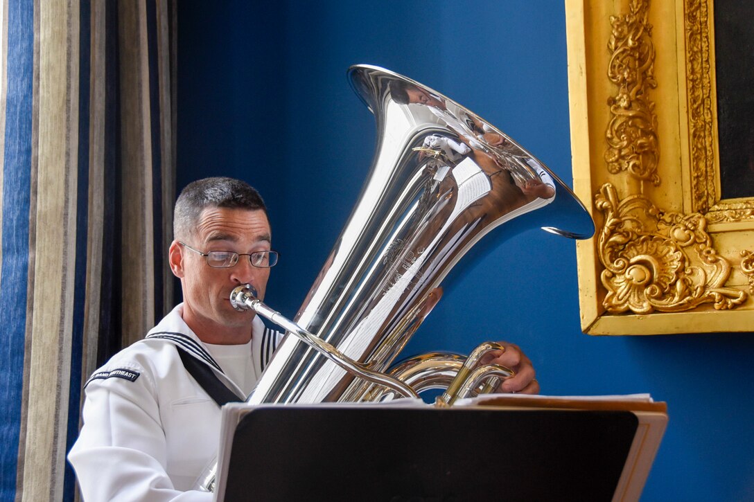 A sailors plays the tuba during a performance.