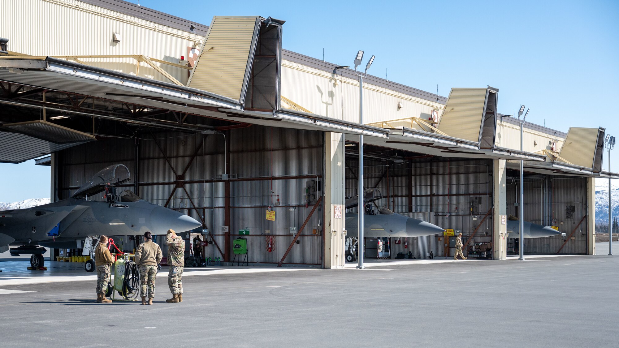 A photo of 3 F-15 Eagles sitting in hangars.